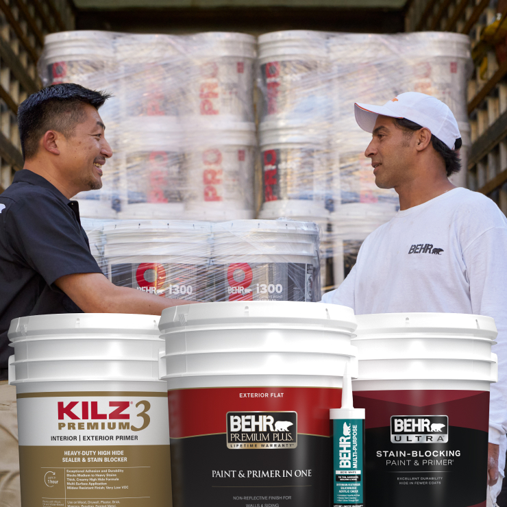 Behr rep talking with painter, 5 gal cans of Behr and Kilz paint