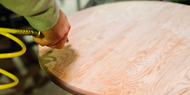 person using air compressor on table