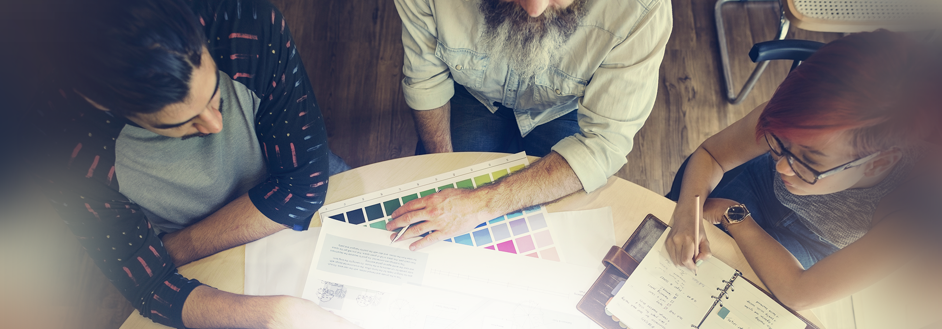 3 people sitting at a table discussing paint colours