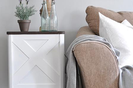 front view of side table with lamp and decor next to sofa