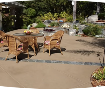 Patio area with table and chairs and landscaping around it