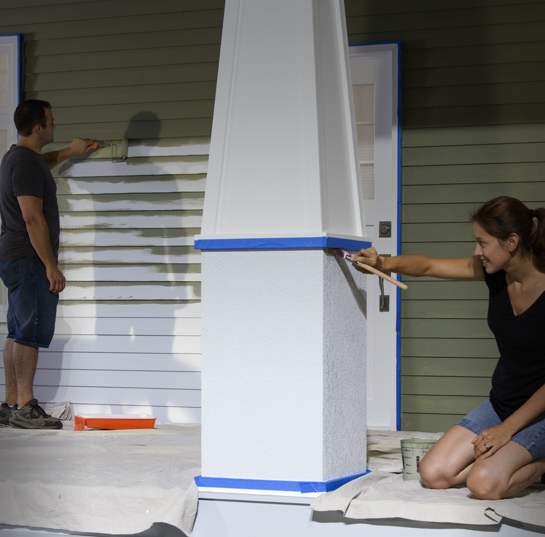 Mobile-sized image of man and woman painting house exterior.