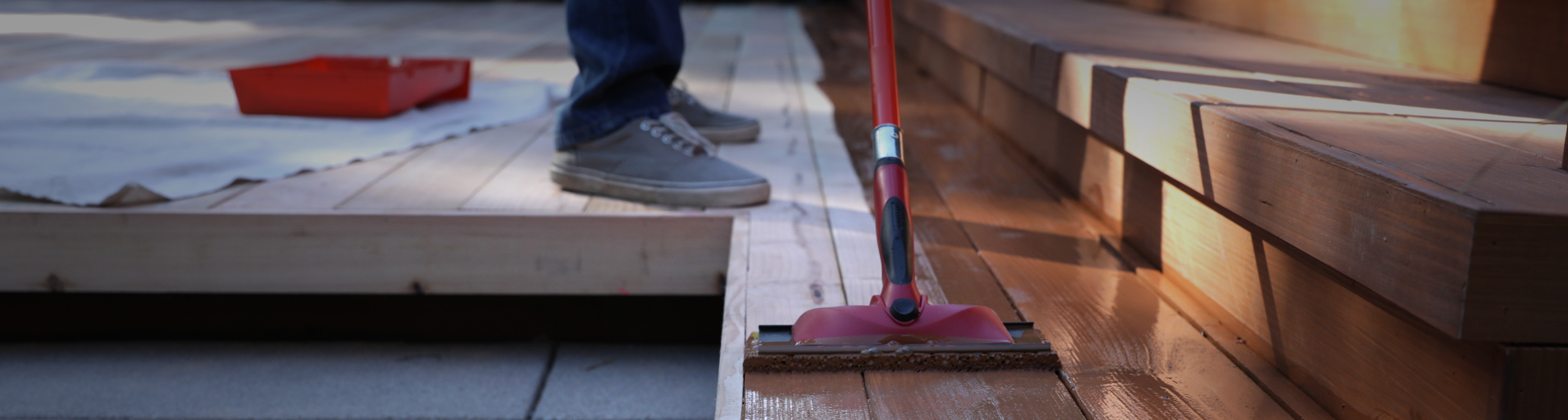 Close up of stain being applied to a deck.