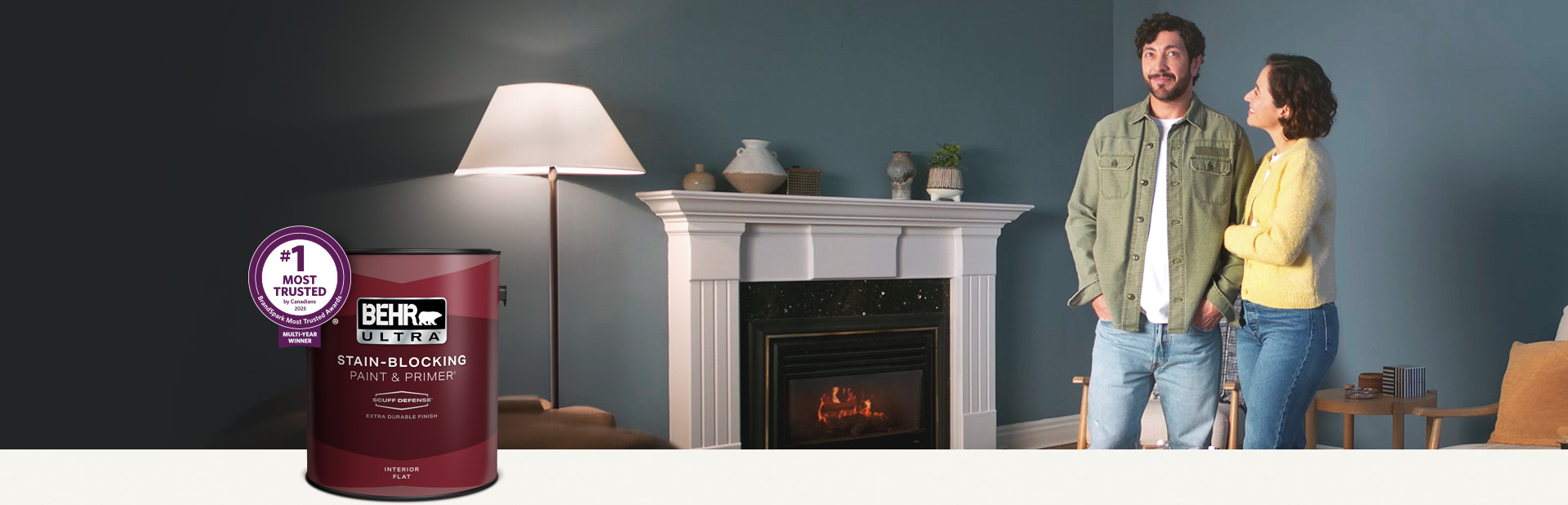 Living room with a pale peach colored wall and a can of Behr Ultra Scuff Defense Interior Paint in the foreground