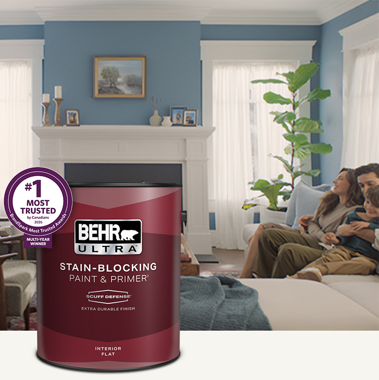 Living room with a pale peach colored wall and a can of Behr Ultra Scuff Defense Interior Paint in the foreground mobile image.