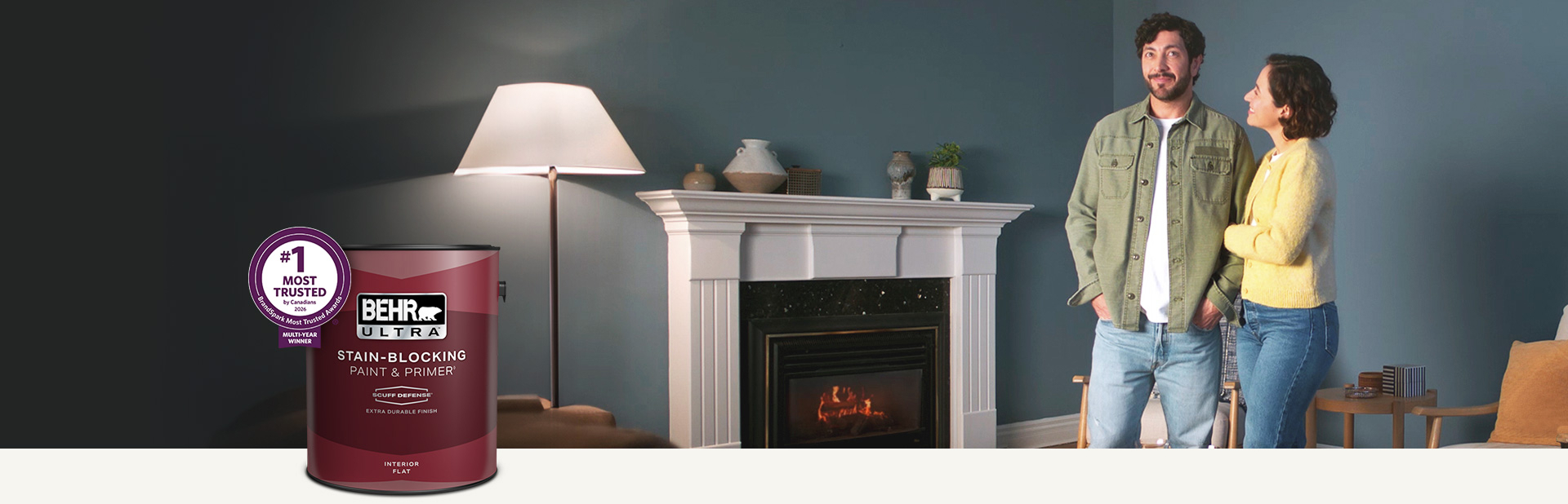 Living room with a pale peach colored wall and a can of Behr Ultra Scuff Defense Interior Paint in the foreground