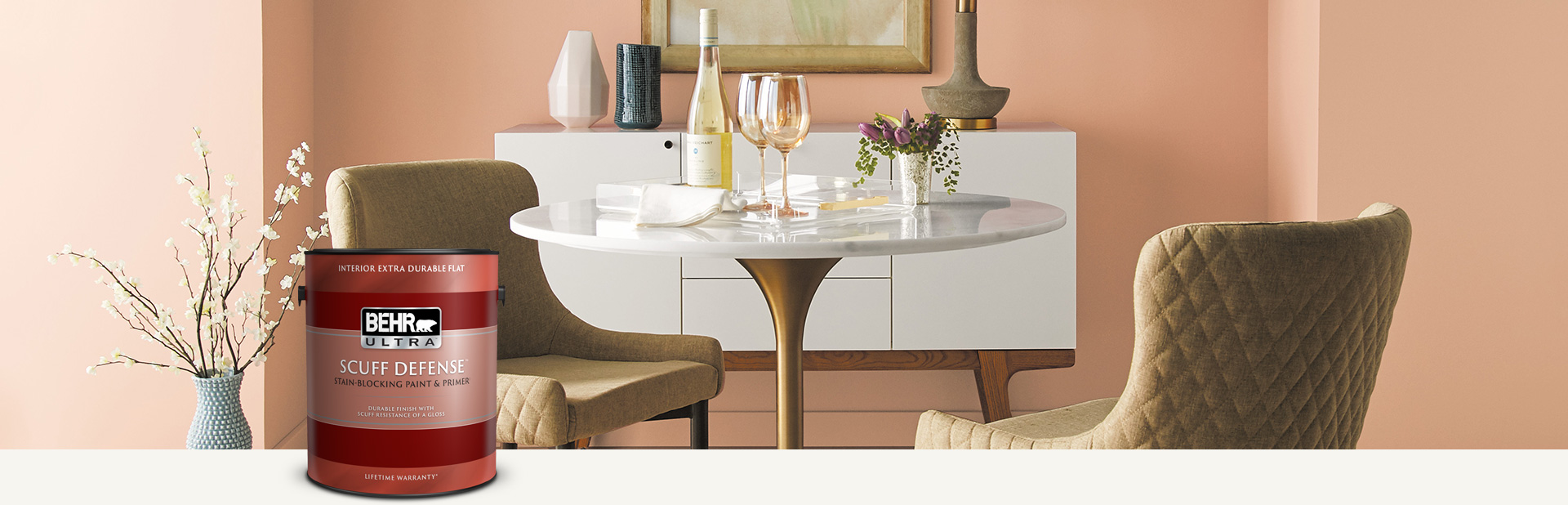 Dining room with a peach colored wall and a can of Behr Ultra Scuff Defense Interior Extra Flat Paint in the foreground