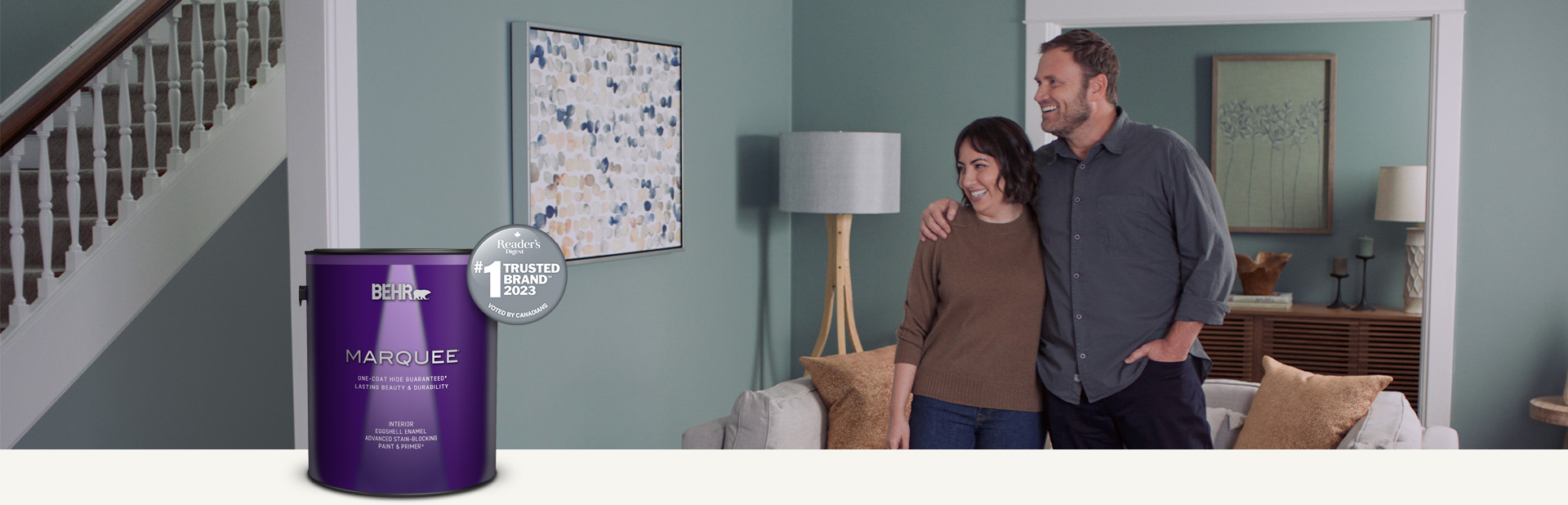 Living room painted in Marquee interior paint with a smiling couple in the background
