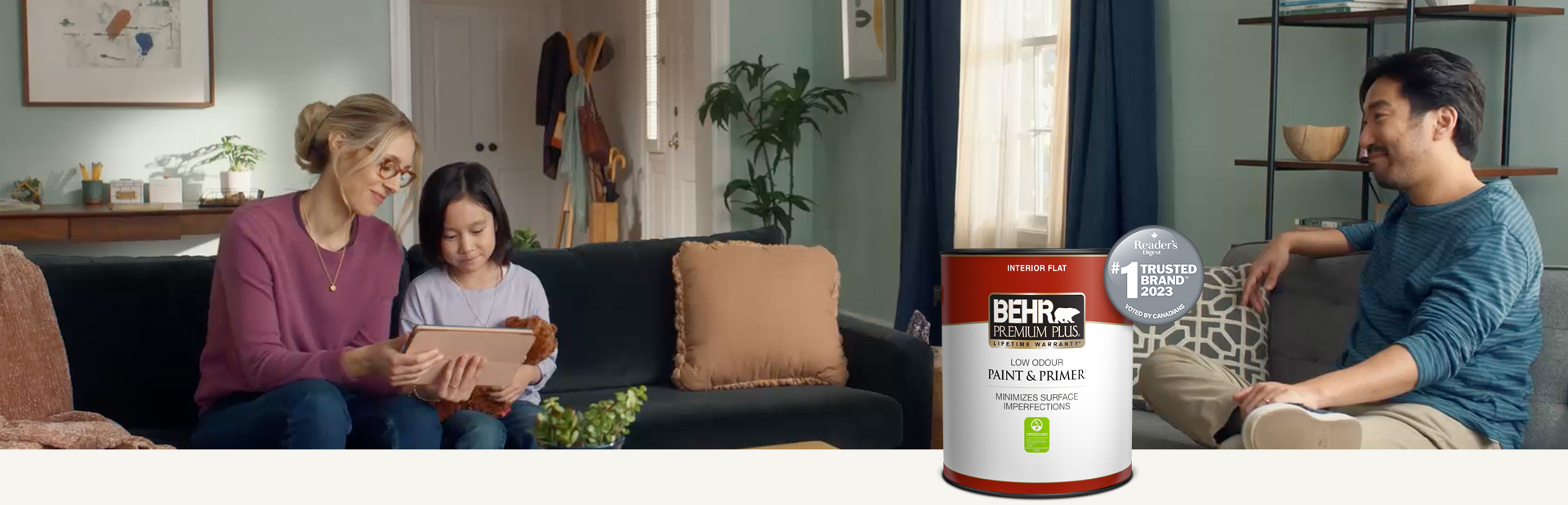 Family sitting in a painted living room with a Behr Premium Plus Interior Flat Paint
