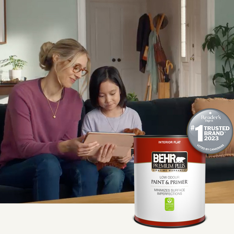 Mobile version of a family sitting in a painted living room with a Behr Premium Plus Interior Flat Paint