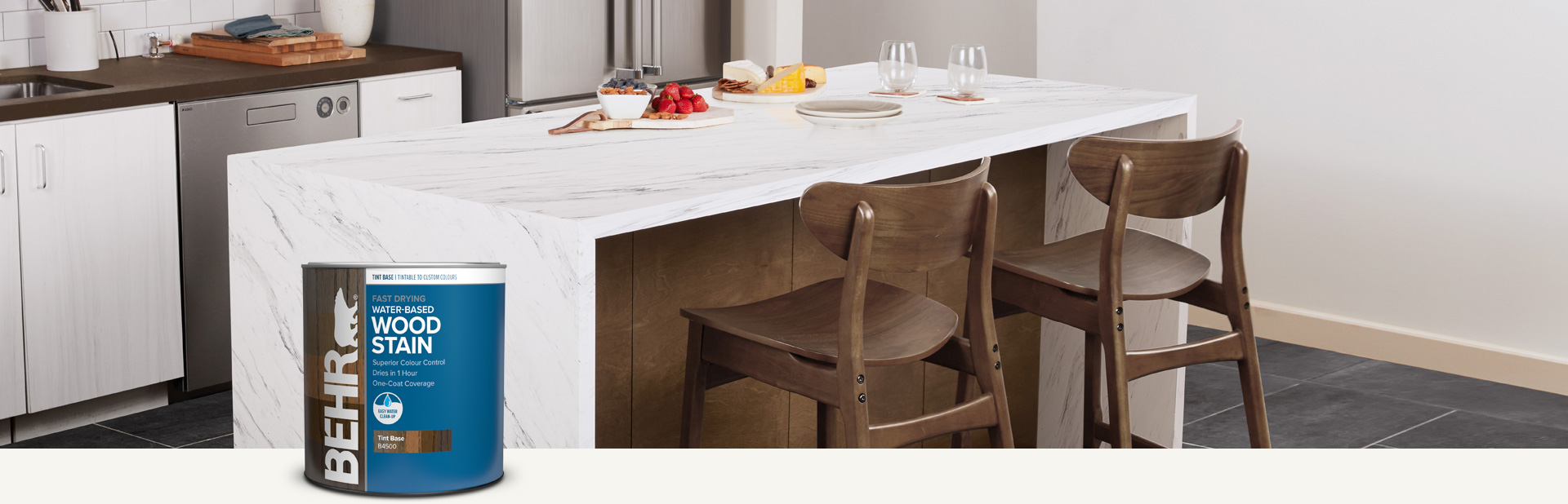 Two ladies sitting at stained dining table with Behr interior wood stain products in foreground