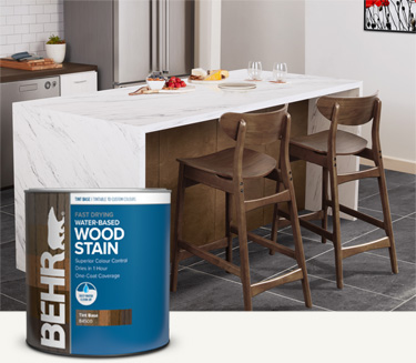 Two ladies sitting at stained dining table with Behr interior wood stain products in foreground mobile