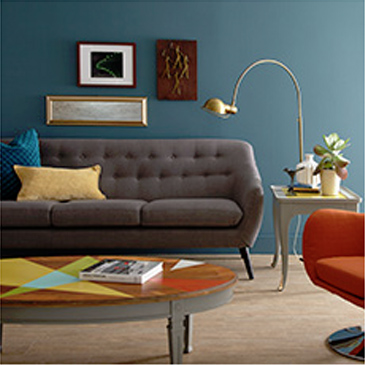 Living room with dark grey couch, orange chair, and coffee table