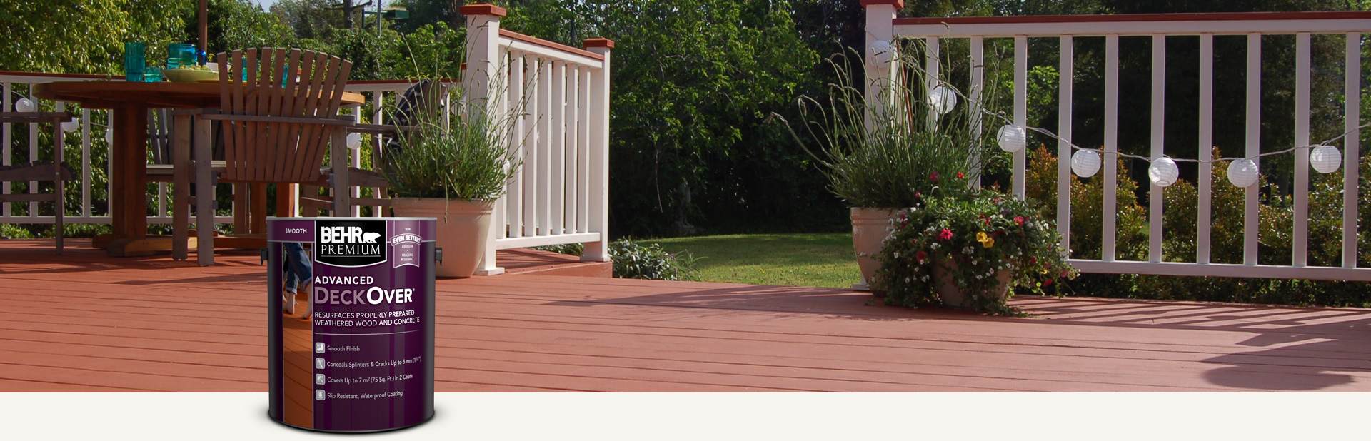 Two cans of Behr Premium Advanced DeckOver Coating with a wooden deck, product can, and brush in the background