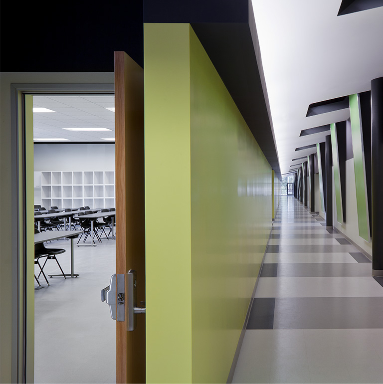 An image of a small empty classroom hallway with a green, grey and white colour combination.
