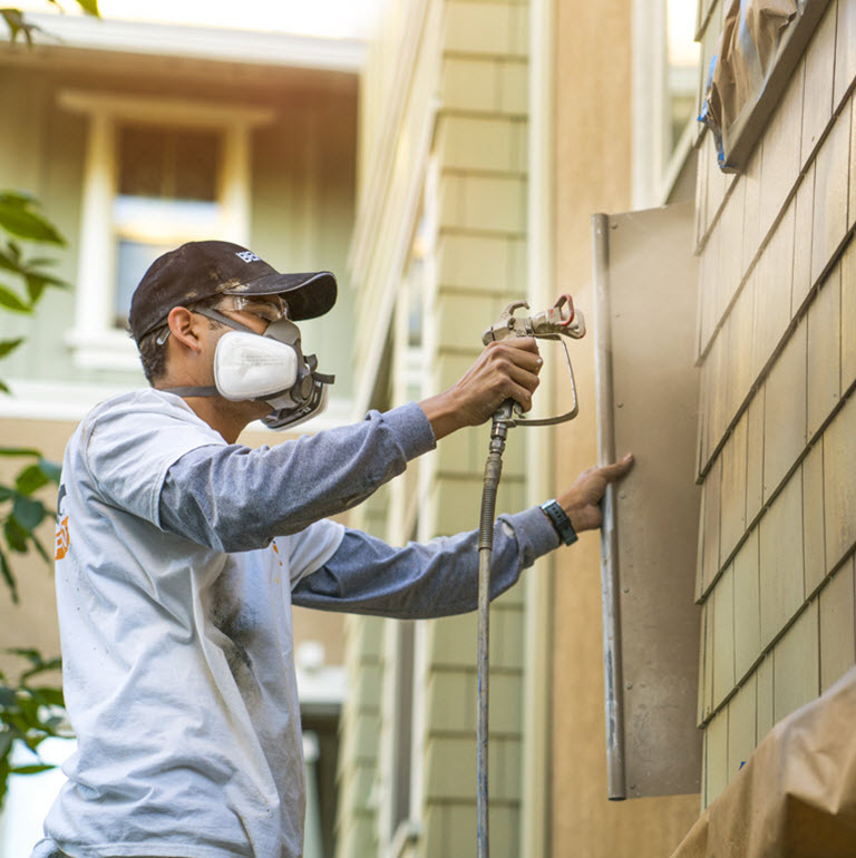 Small image of 2 Pro painters painting the wooden railings of the exterior of an apartment block