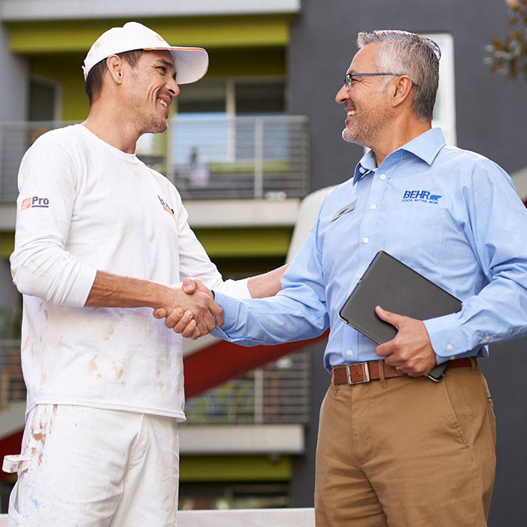 A BEHR PRO Rep shaking hands with a Pro Painter.