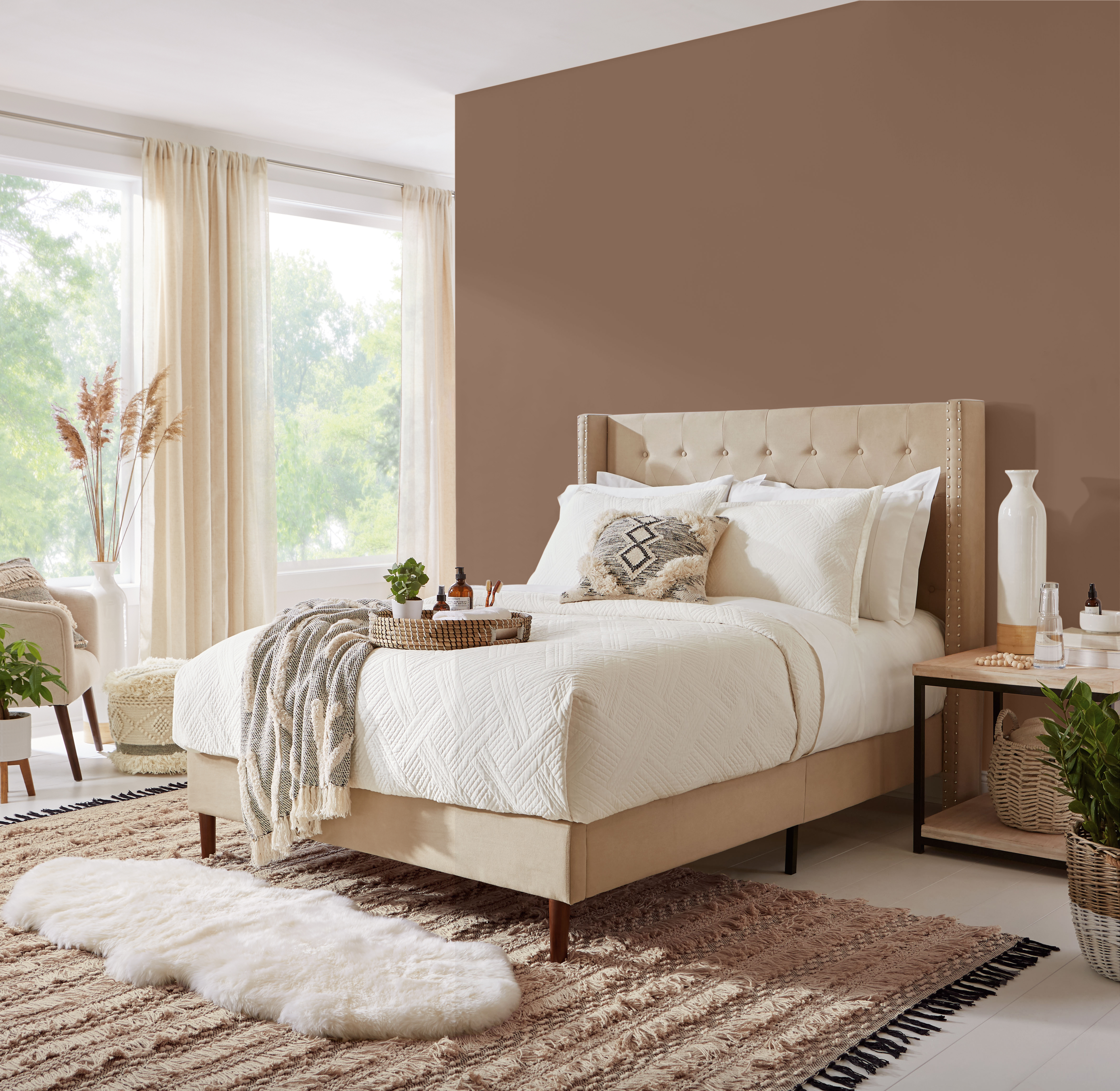 A contemporary/boho bedroom with large windows.  There is a comfy bed with white simple bedding.  One is painted in dark brown color called Wild Mustang.  