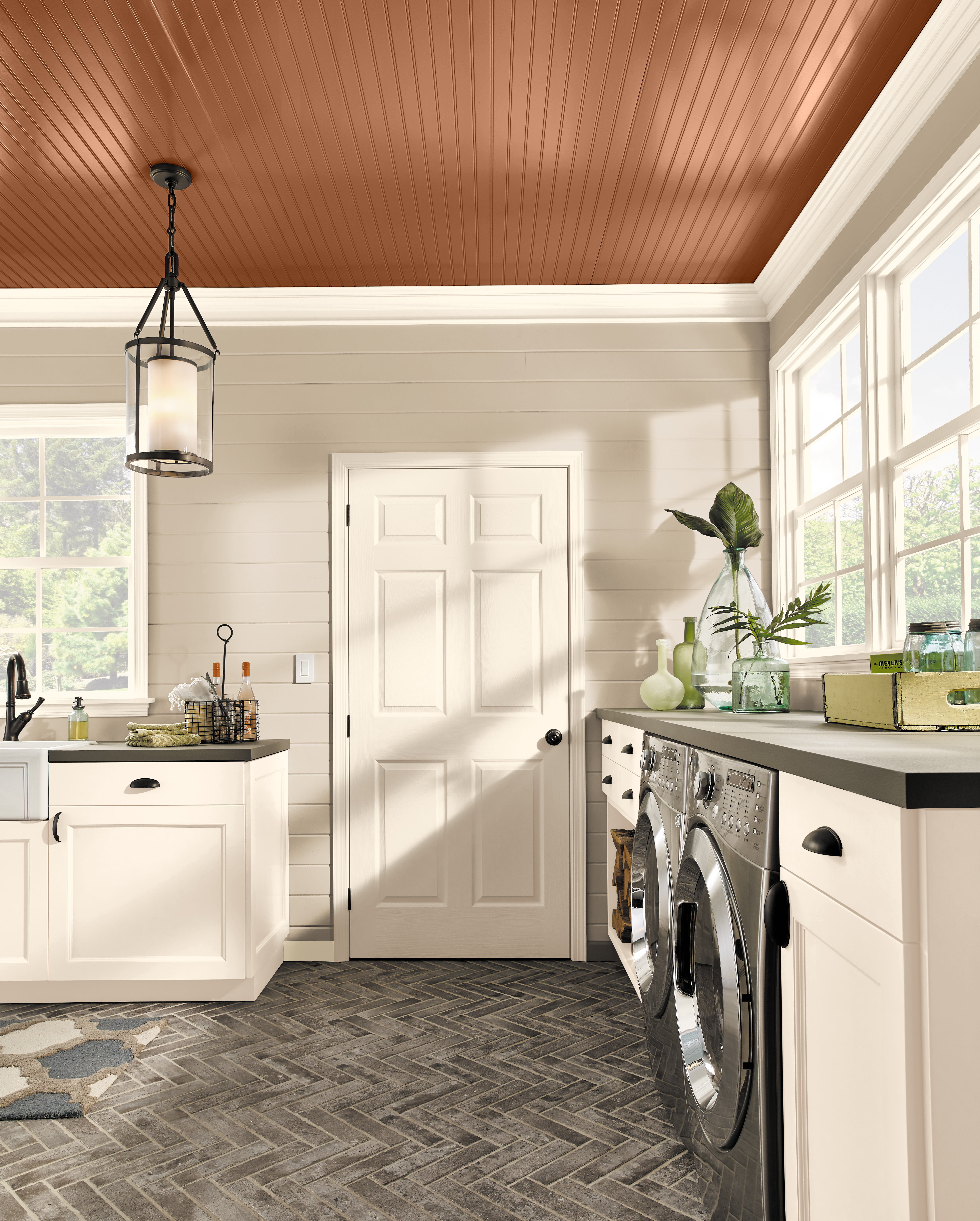 A laundry room painted in a light neutral colors which make the overall room feel expansive and bright.  The ceiling painted color is a mid-to-dark warm tone called Maple Glaze. 