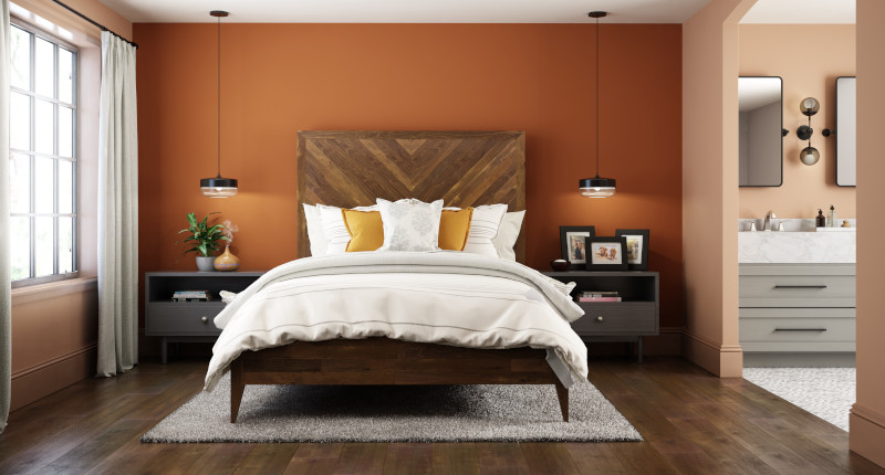 A large master bedroom and bathroom, both room are painted with orange tones.  The main color is a mid dusty terra cotta called Canyon Dusk and the accent color used on the headboard wall is called Maple Glaze. 