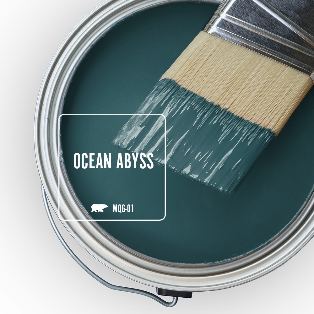The top view of an open paint can, the color being featured is a dramatic teal color called Ocean Abyss.  There is a half dipped paint brush leaning on top of the open can. 