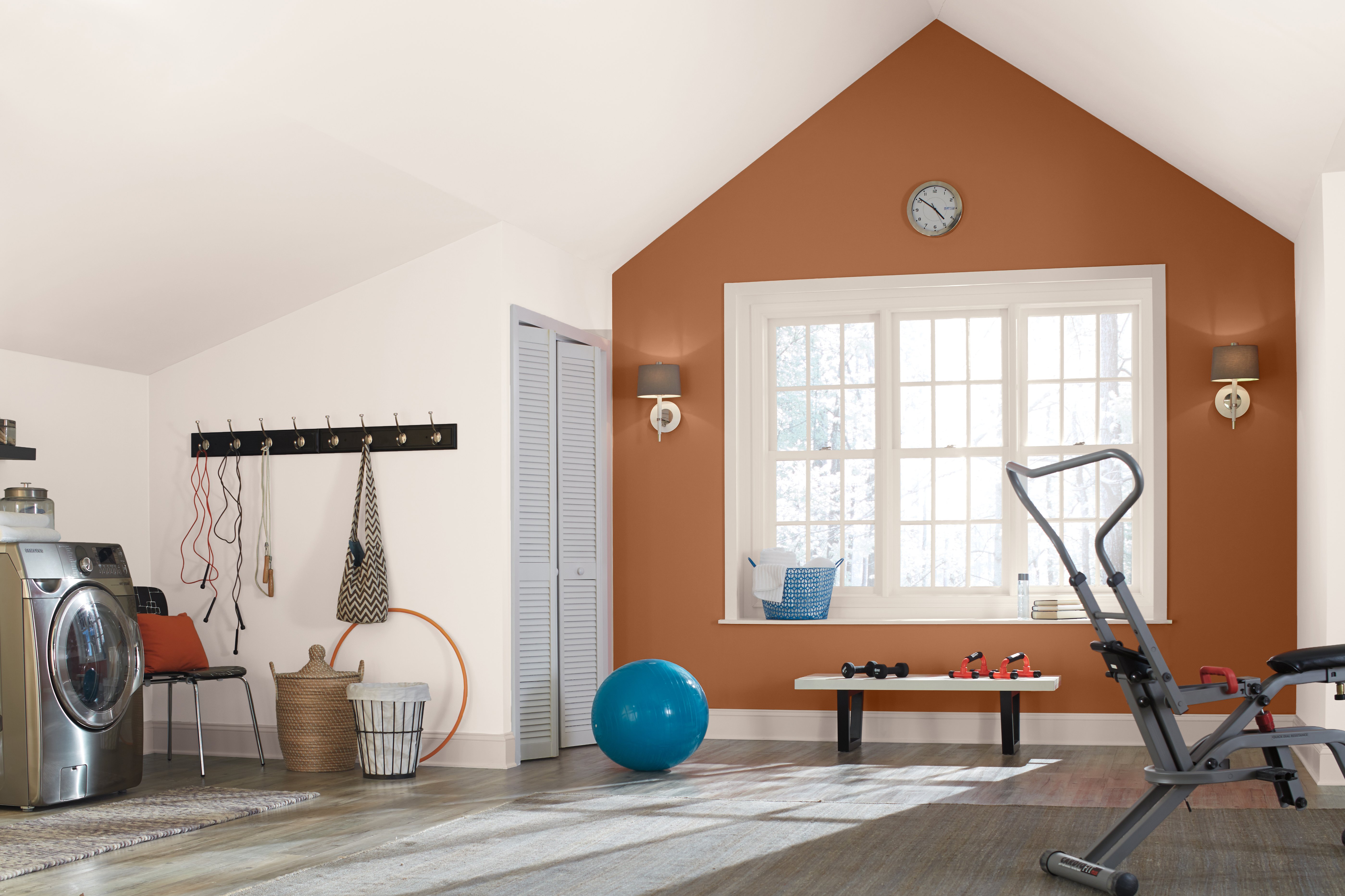 A large multi-purpose room  painted in a white color, there is a terra cotta color featured as an accent wall.  
The accent color is called Maple Glaze and it helps highlight the architecture of this room. 