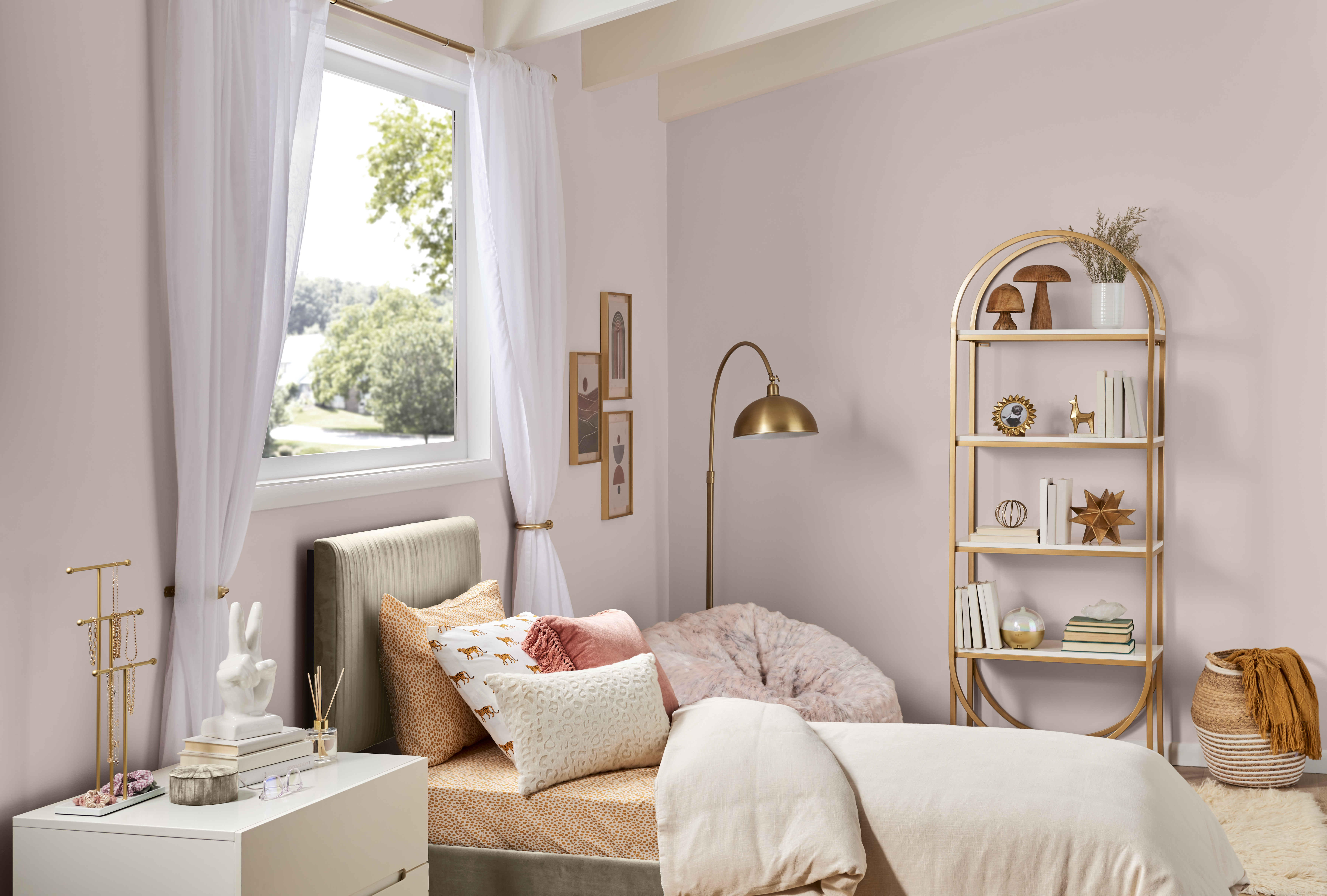 Une chambre chic avec des murs peints en une teinte de rose chaud et saturé. Accessoires et meubles d'accent dorés. 