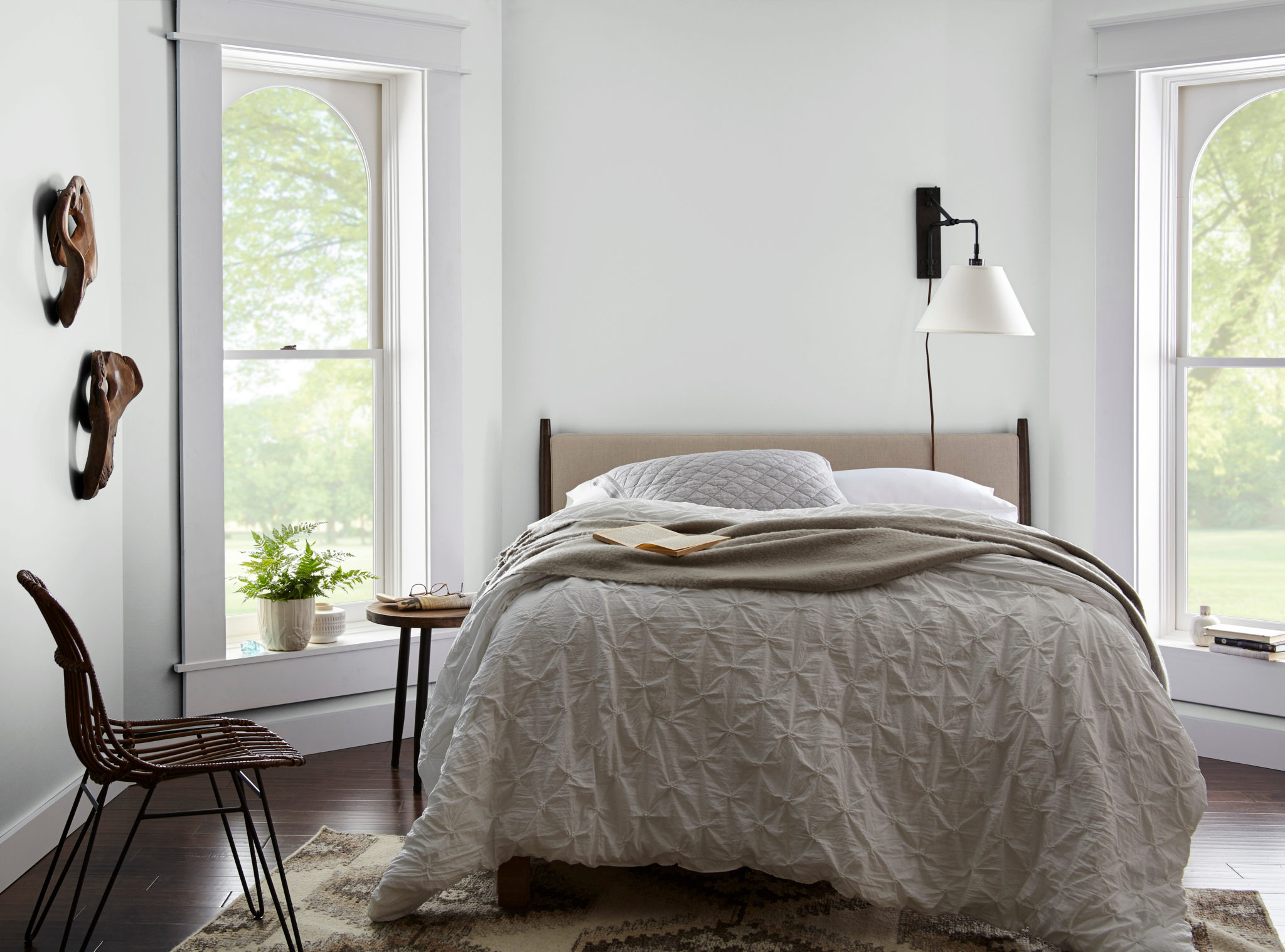 An casual-eclectic bedroom featuring simple furniture and some wood decorative elements, the color featured on the walls is cool white called Frost. 