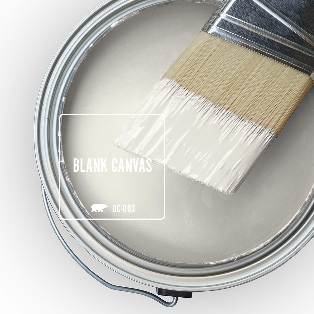 The top view of an open paint can with wet paint and a half-dipped paint brush, featuring the colour Blank Canvas.