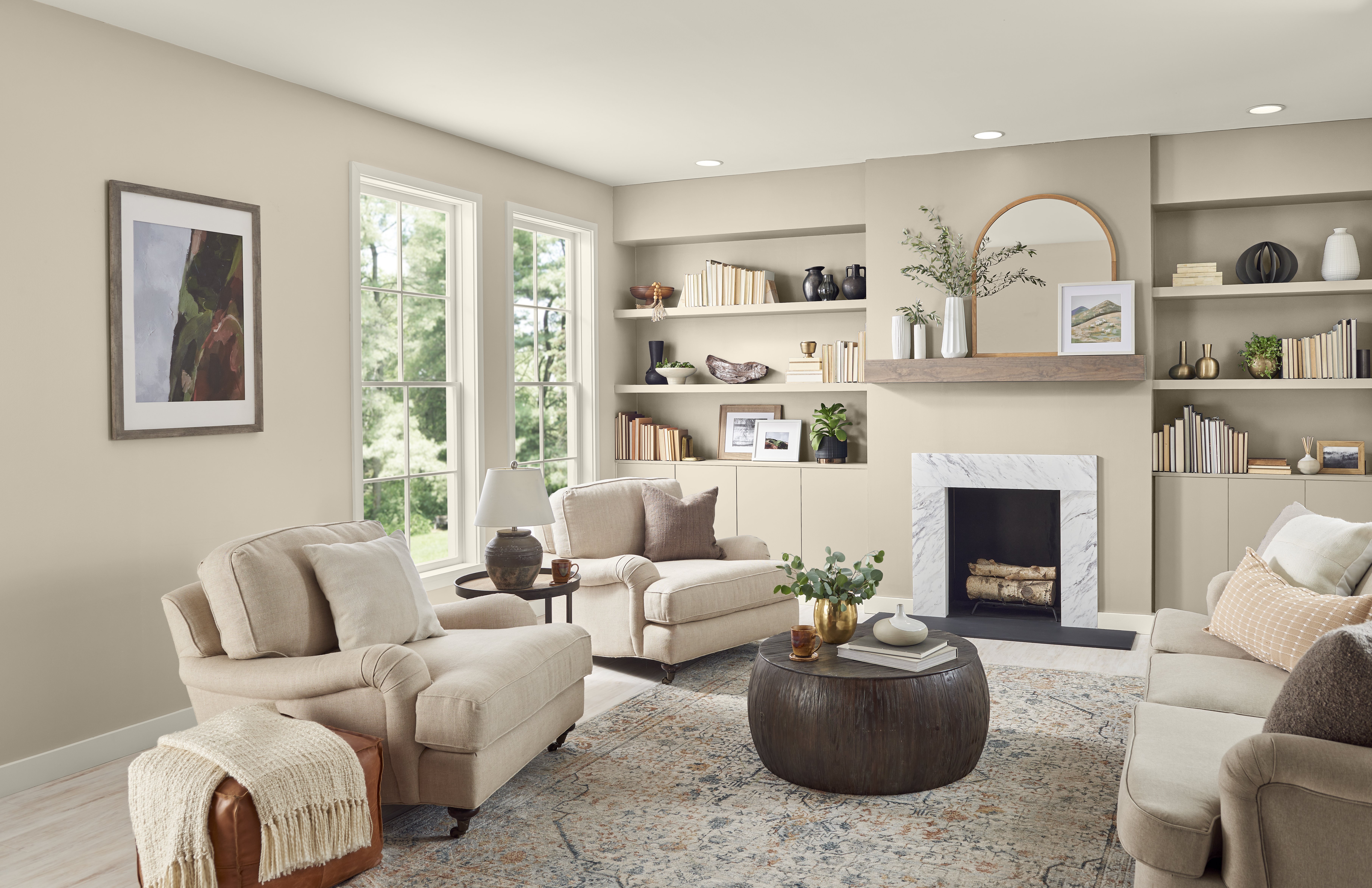 A cozy living room with walls and built-in shelves painted in Even Better Beige, surrounded by matching neutral furniture pieces.