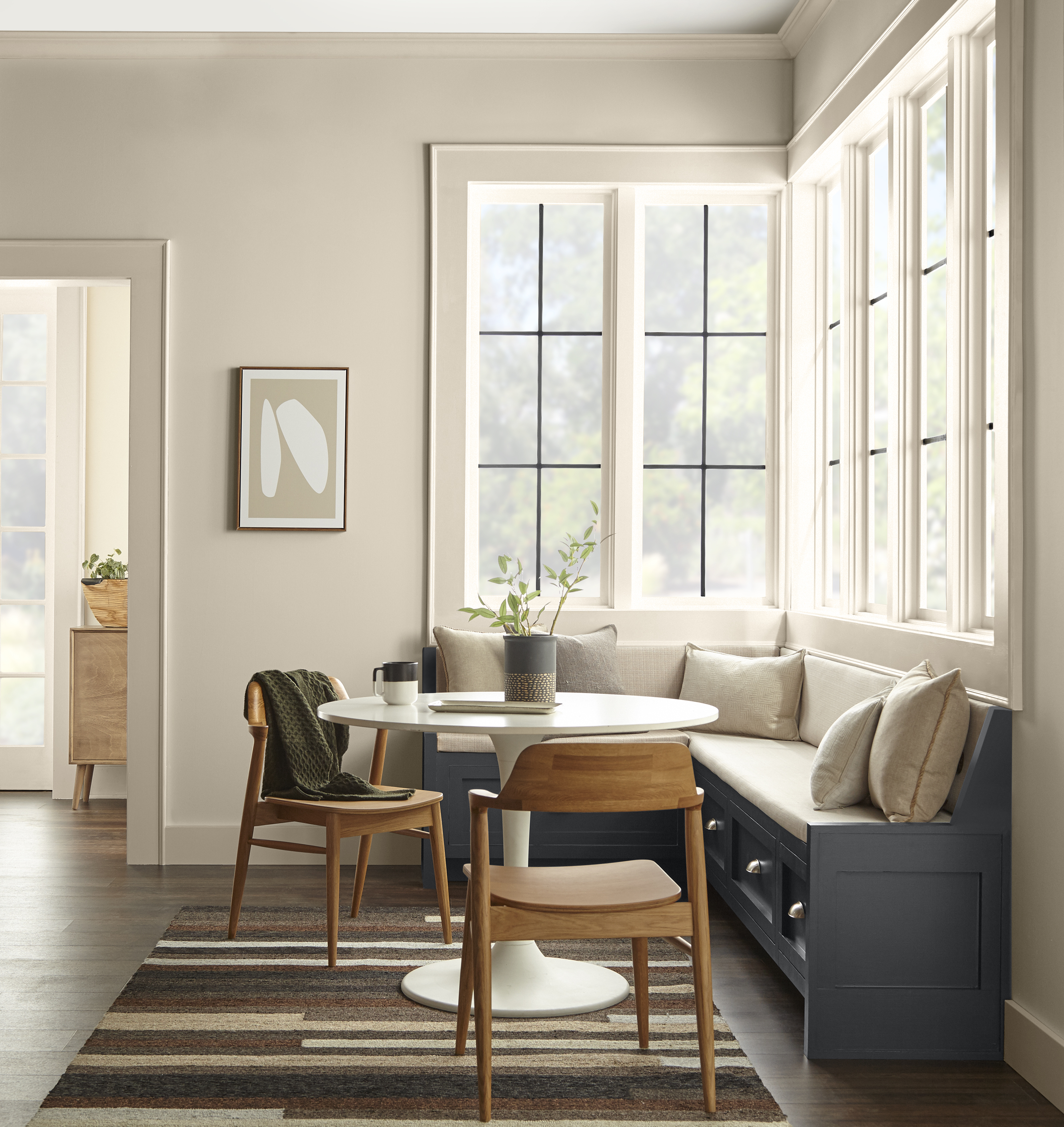 A corner kitchen nook with walls painted in Even Better Beige, and a seating area in a contrasting dark grey colour.