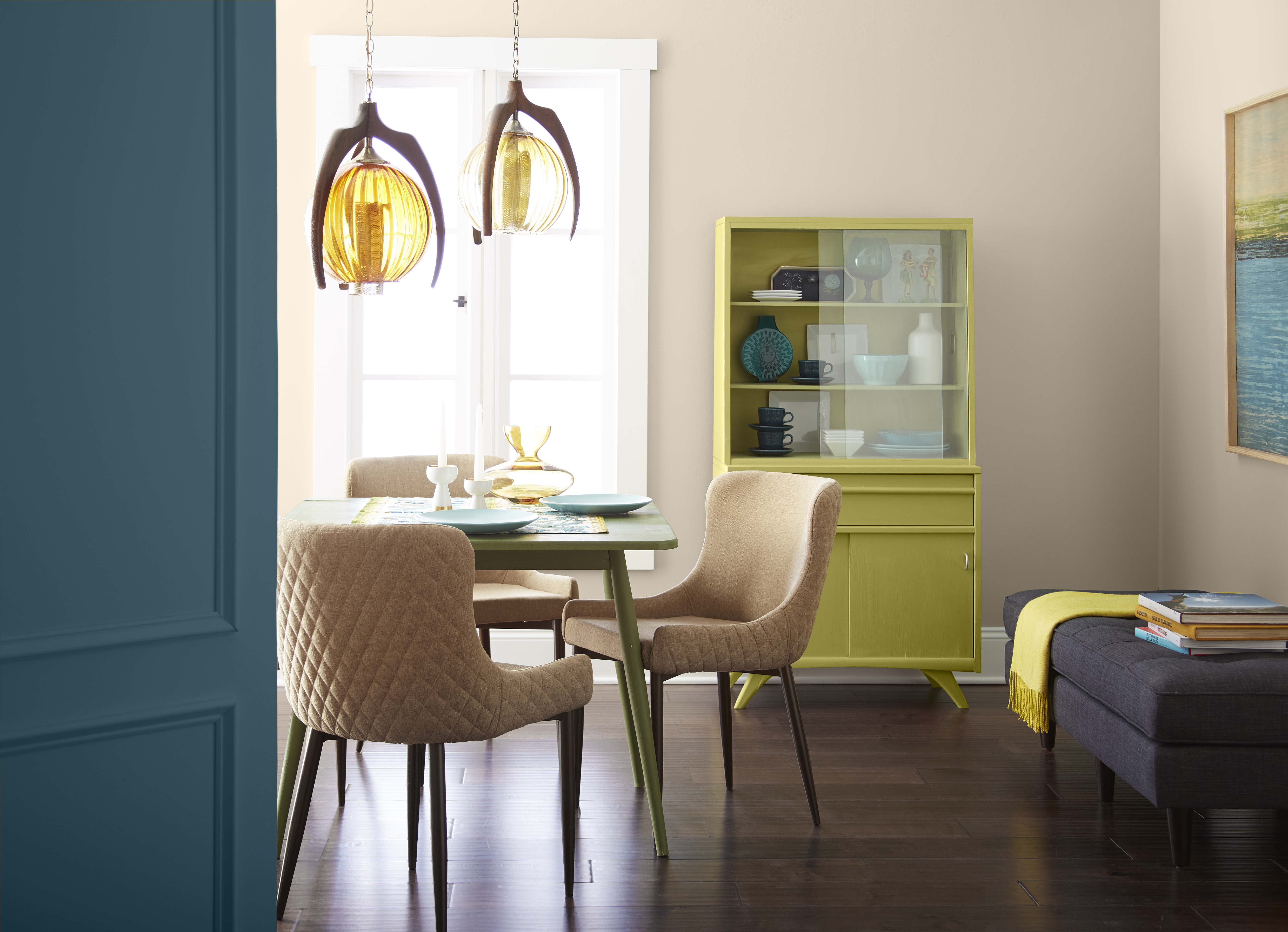 Retro-inspired dining room space with a cabinet painted in a bold light green