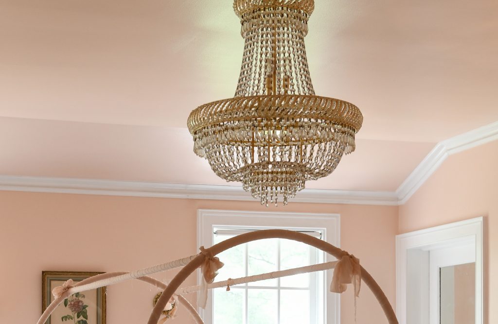 Closeup of the bedroom window and ceiling with a chandelier 