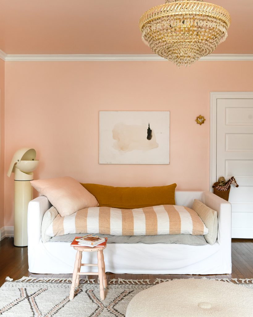 Shot of the room with a white sofa bed styled with colour coordinating pillows and blankets