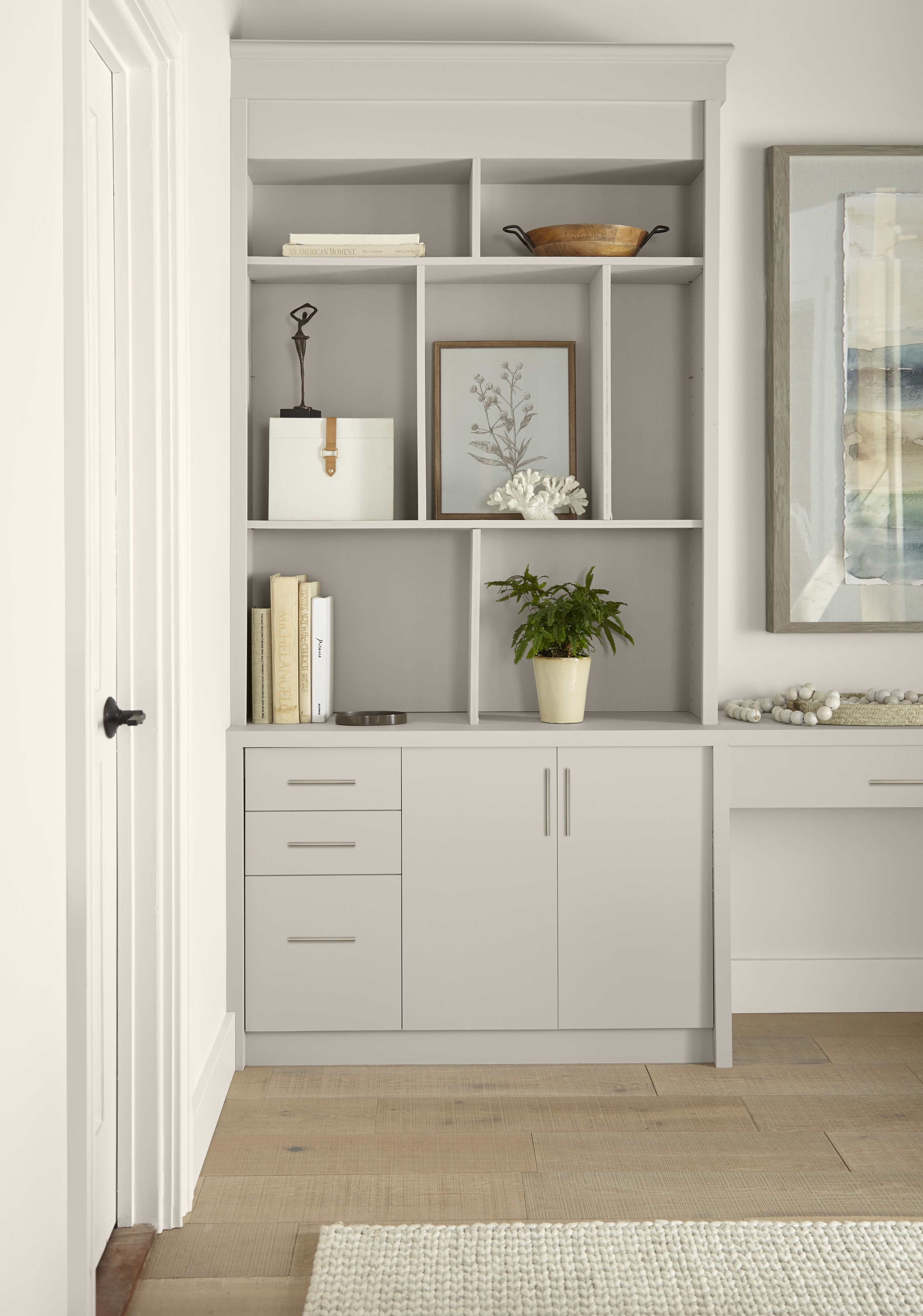 A built-in bookcase painted in Tranquil Gray styled with various décor and accessories