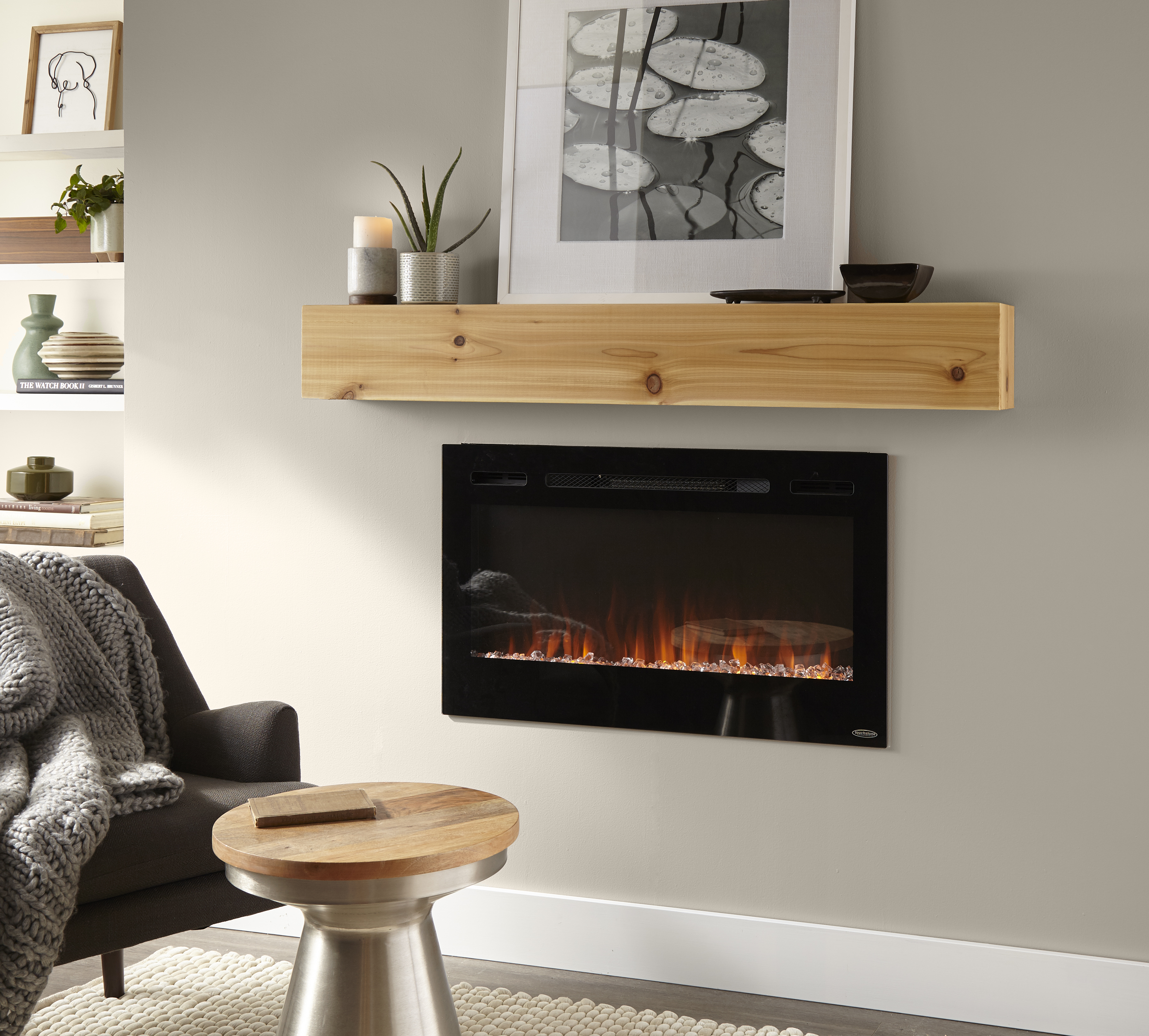 A cozy fireplace set into a wall with a wood mantel above, and walls painted in a warm greige colour