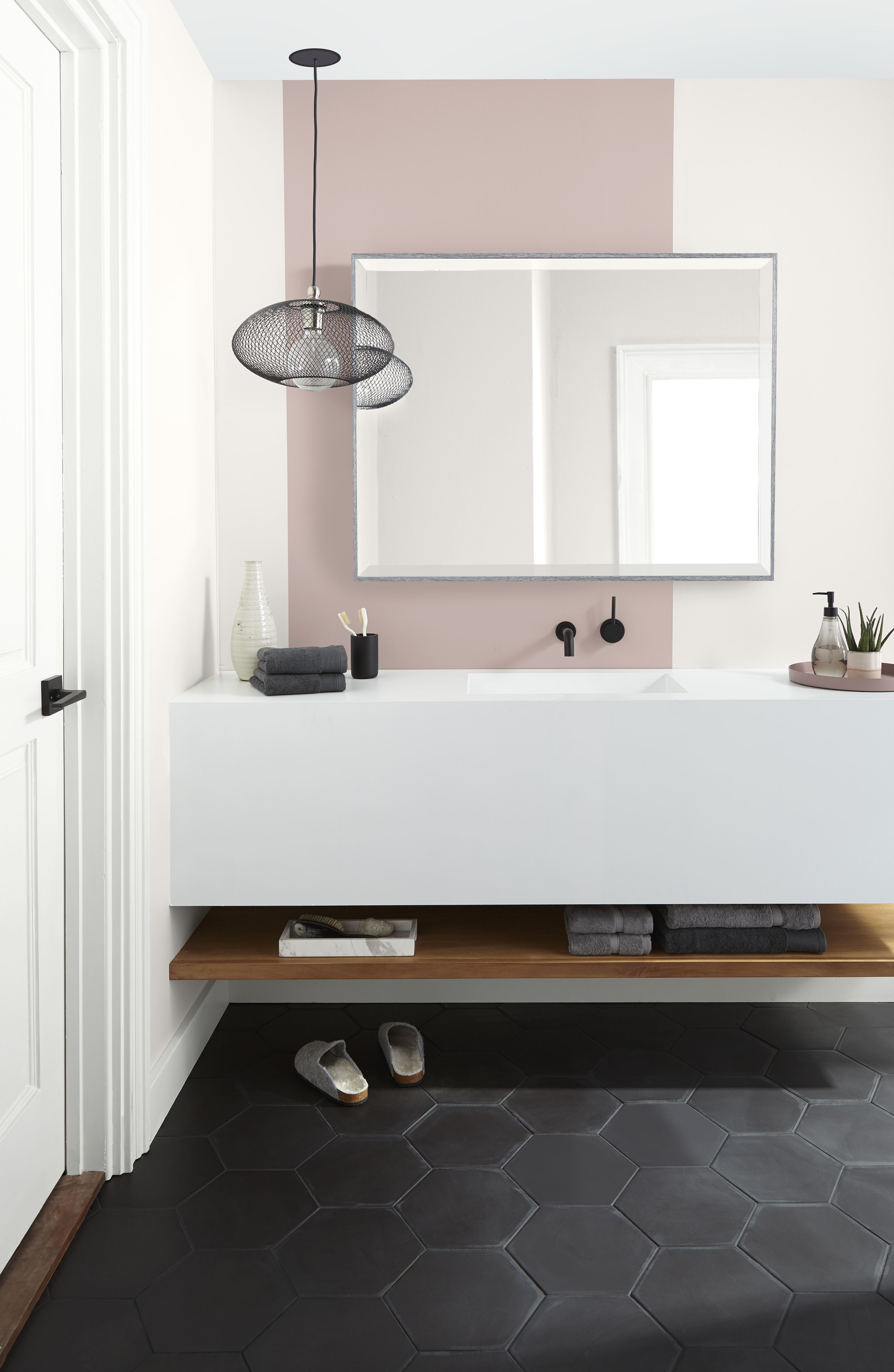 A bright and modern bathroom with a colour blocking design on the wall painted in Smokey Pink