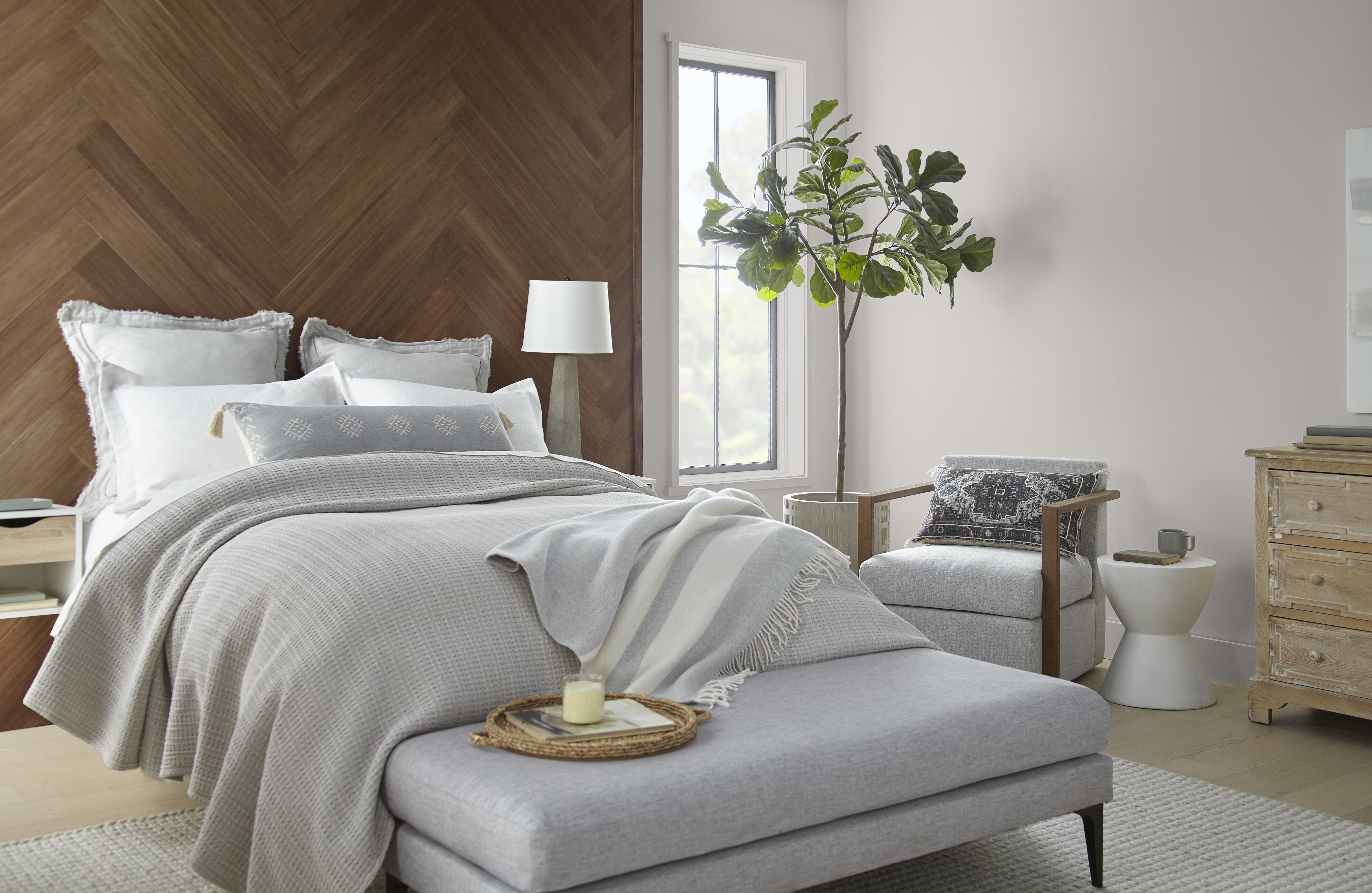 A bedroom with a floor-to-ceiling accent wood headboard and side walls painted in a light greige colour