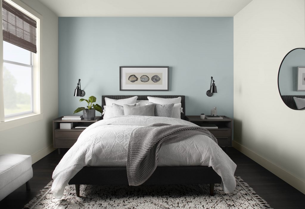 A calming bedroom with an accent wall painted in Urban Raincoat and surrounding walls in Blank Canvas
