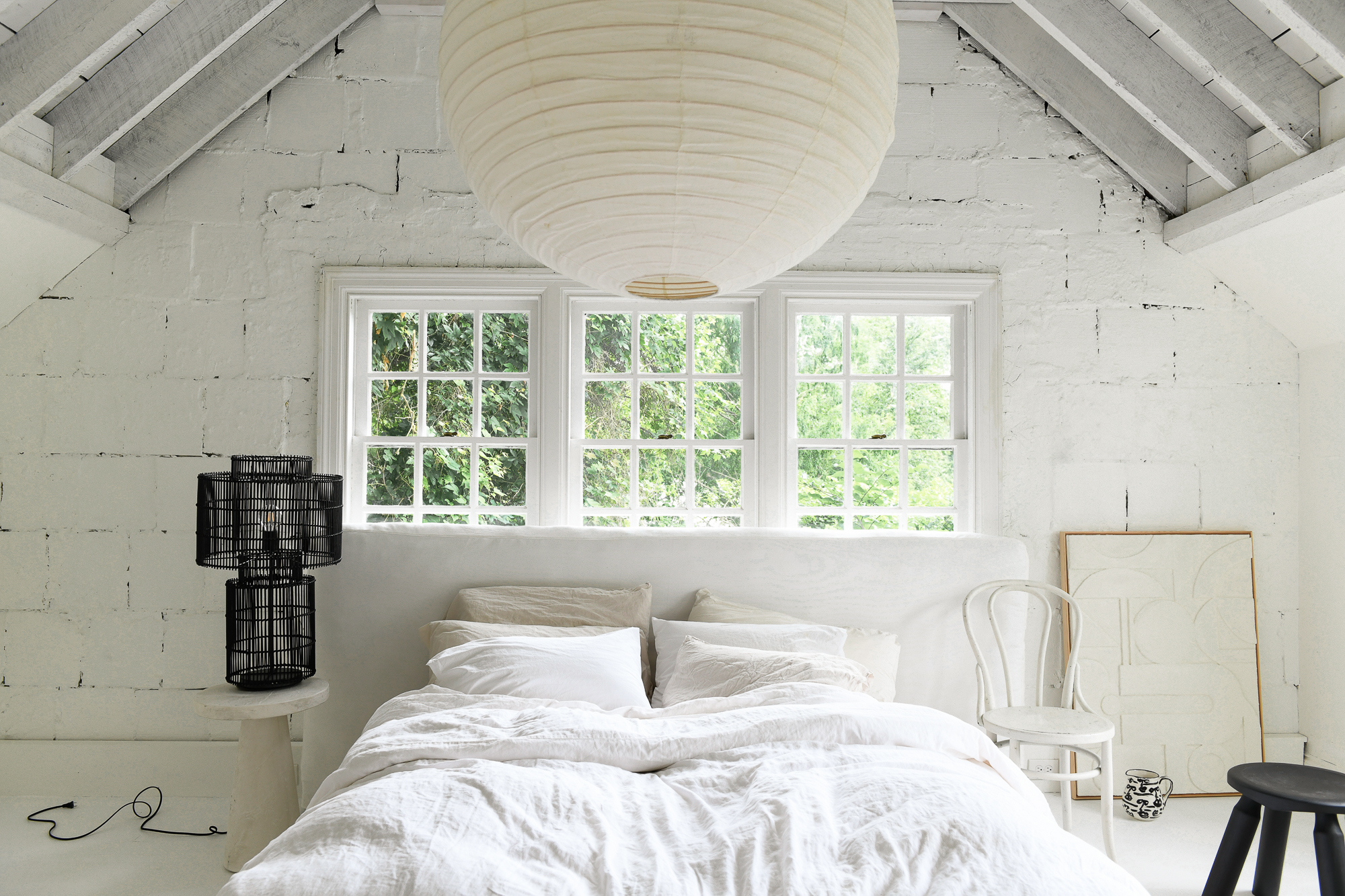Leanne Ford’s rustic bedroom with brick walls and beams painted in Natural White