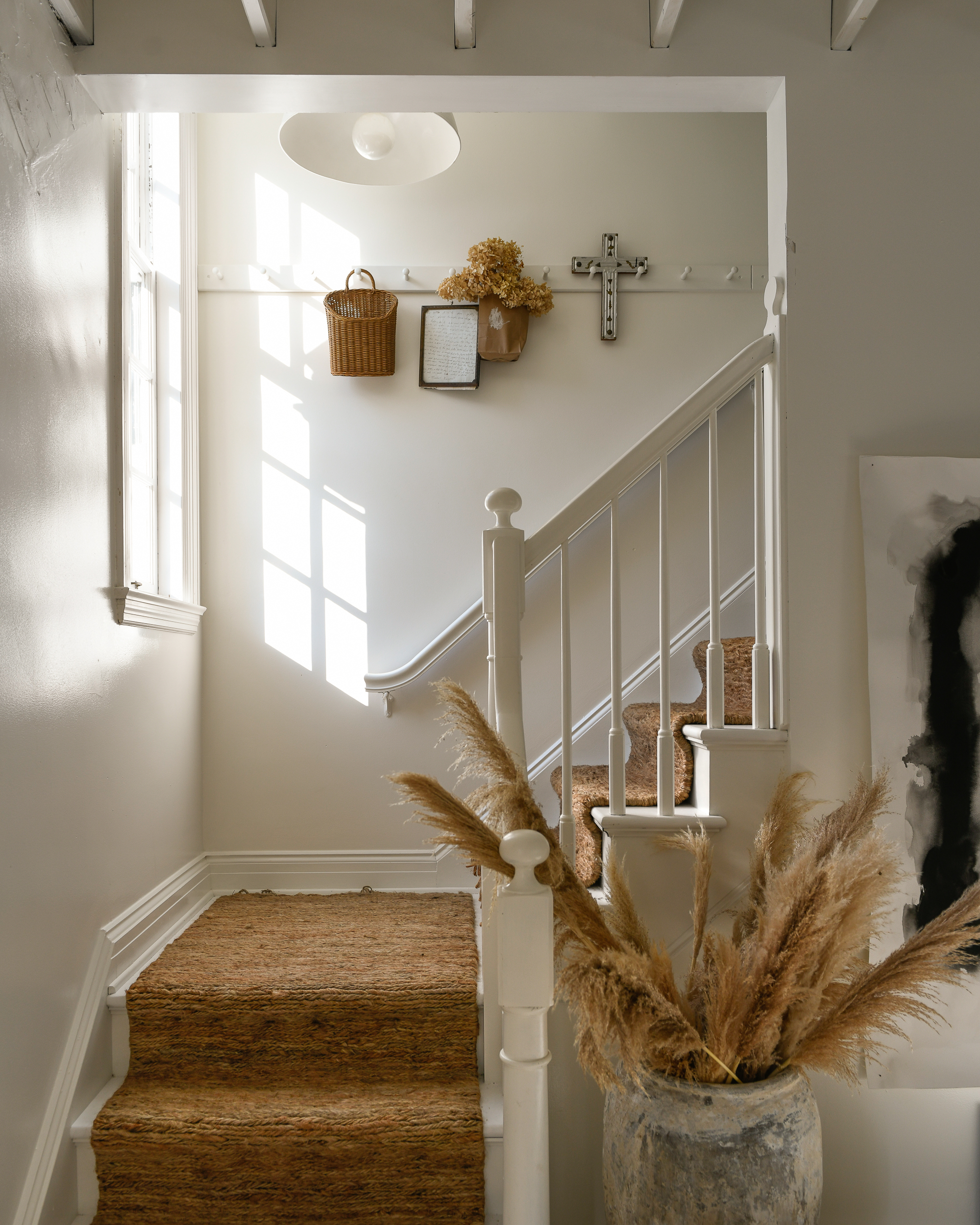Leanne Ford’s stairway with walls painted in Natural White and styled with brown accents