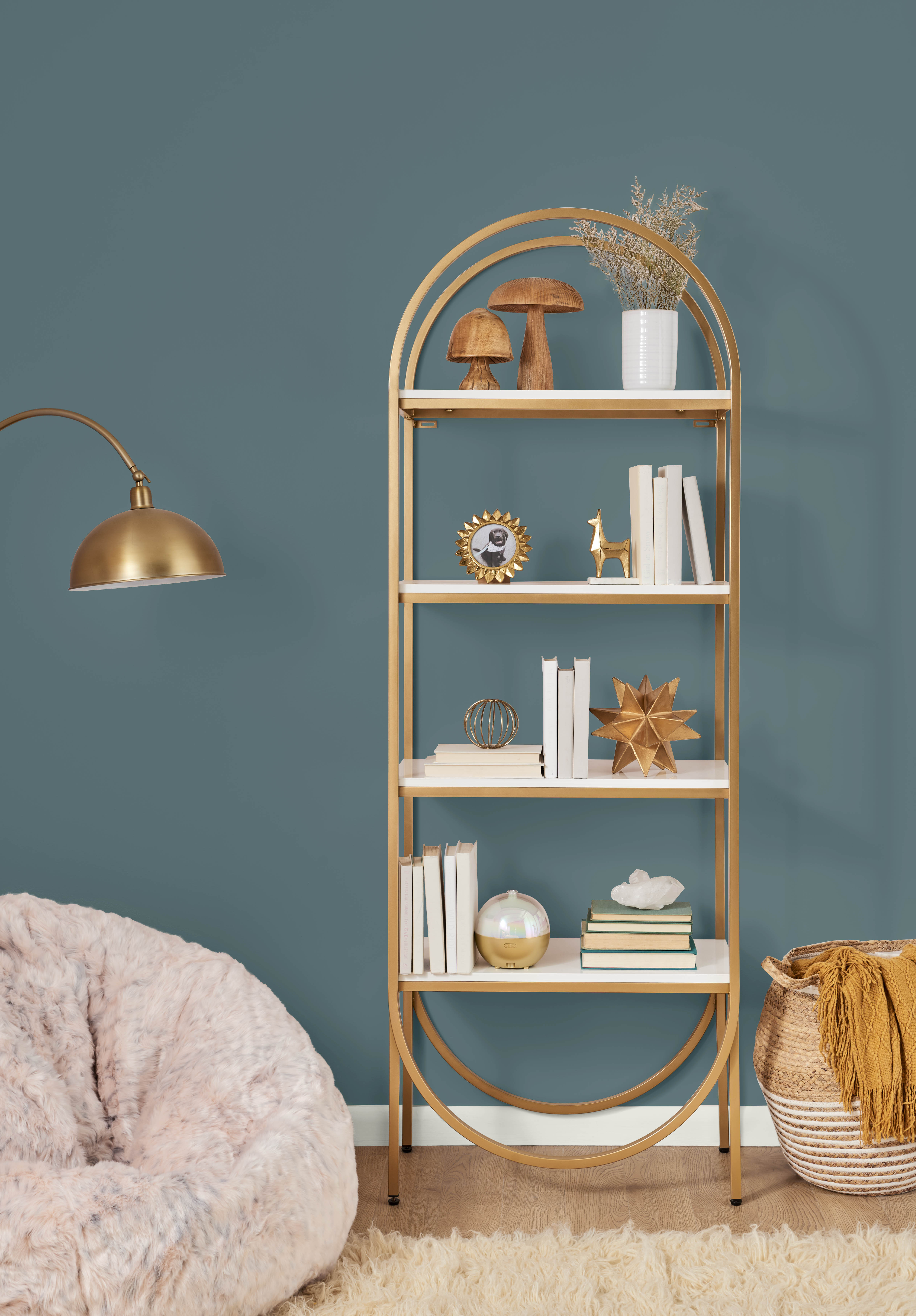 A closeup of a room in the colour Sophisticated Teal, styled with a metallic gold bookshelf and lamp