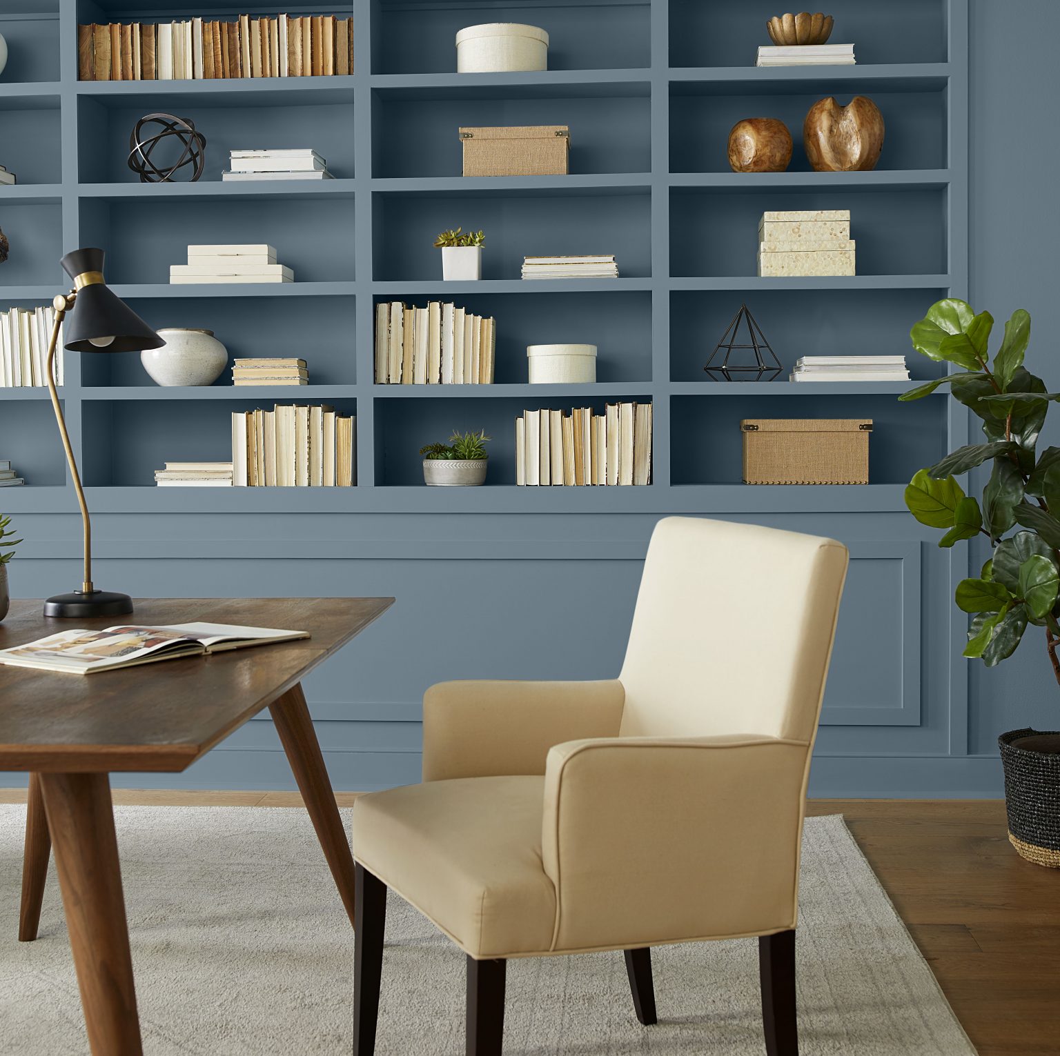 A closeup of a home office with built-in shelves painted in Adirondack Blue
