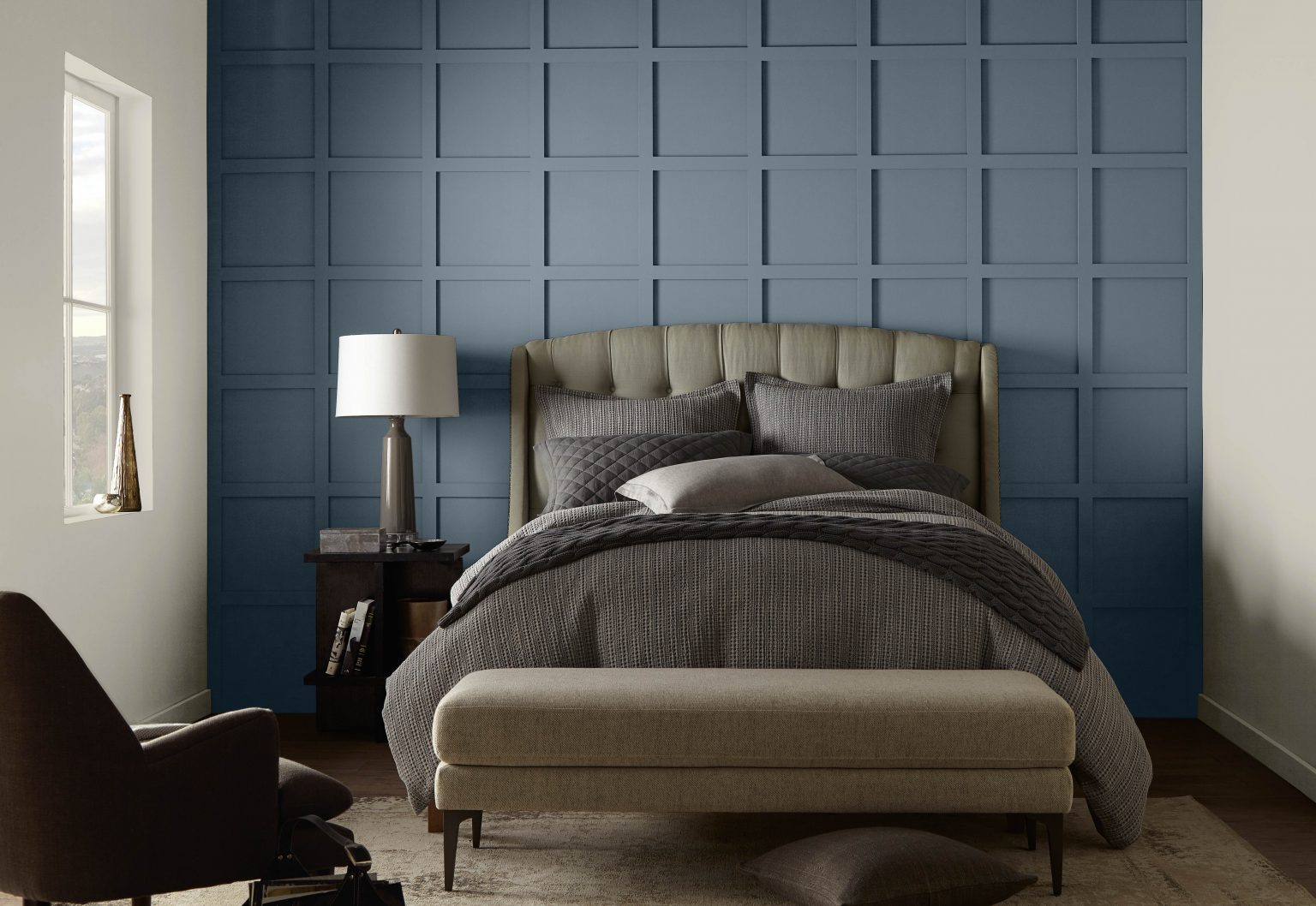 A sophisticatd bedroom with an accent wall painted in Adirondack Blue