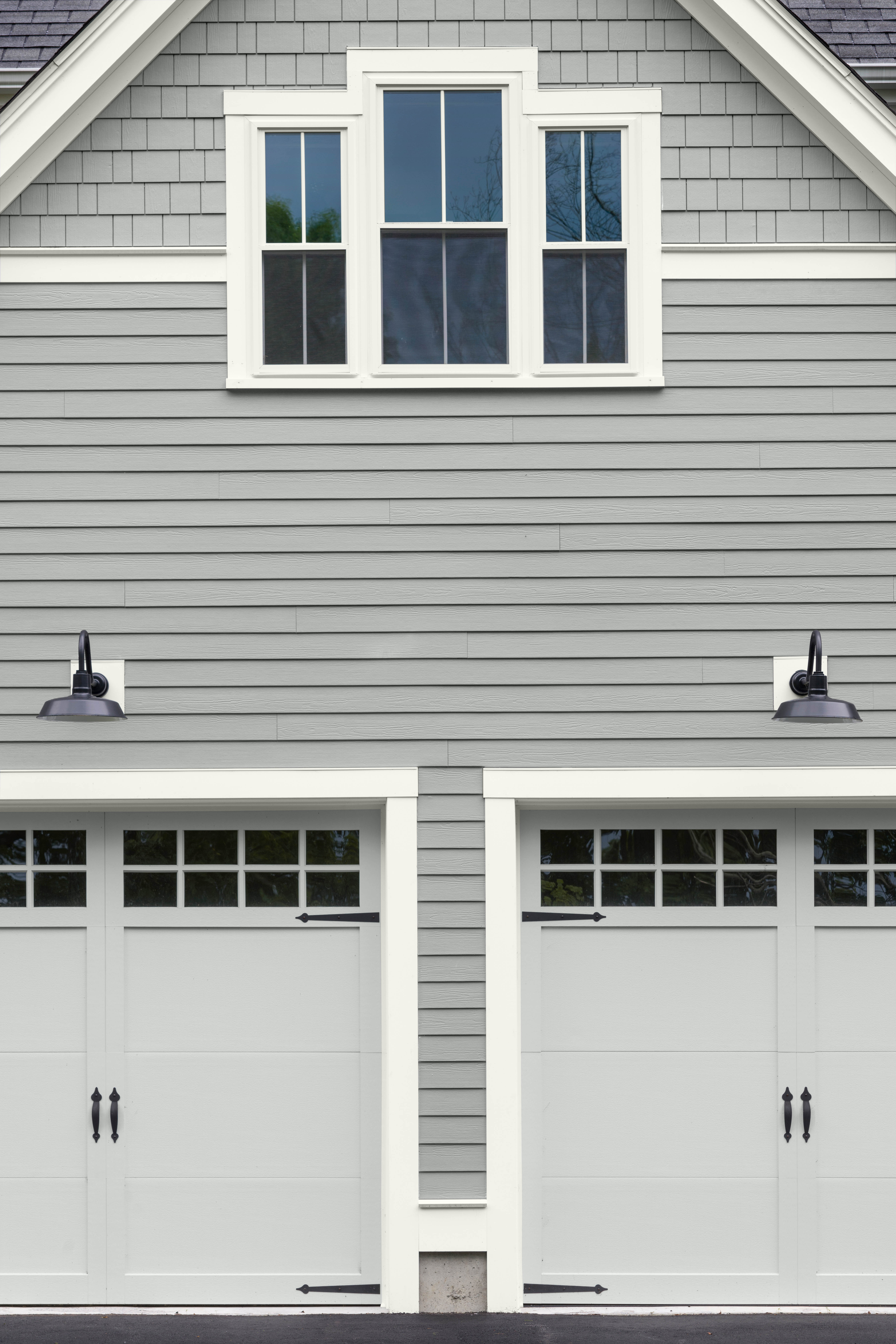 The exterior of a house with siding in the colour Lunar Surface and garage doors in the colour Platinum