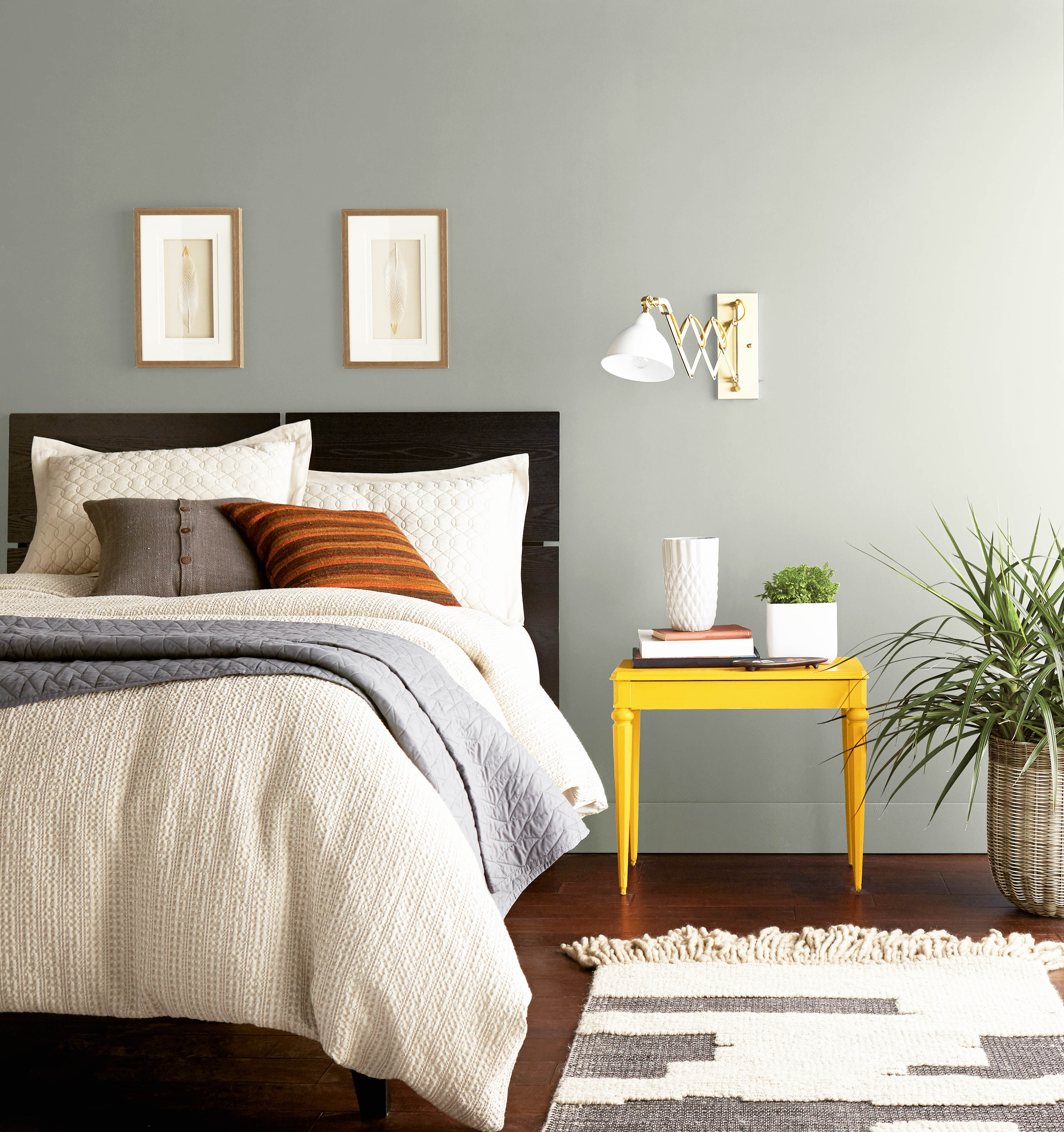 A bedroom with walls in the colour Silver Feather and styled with pops of colour in the furniture and décor 