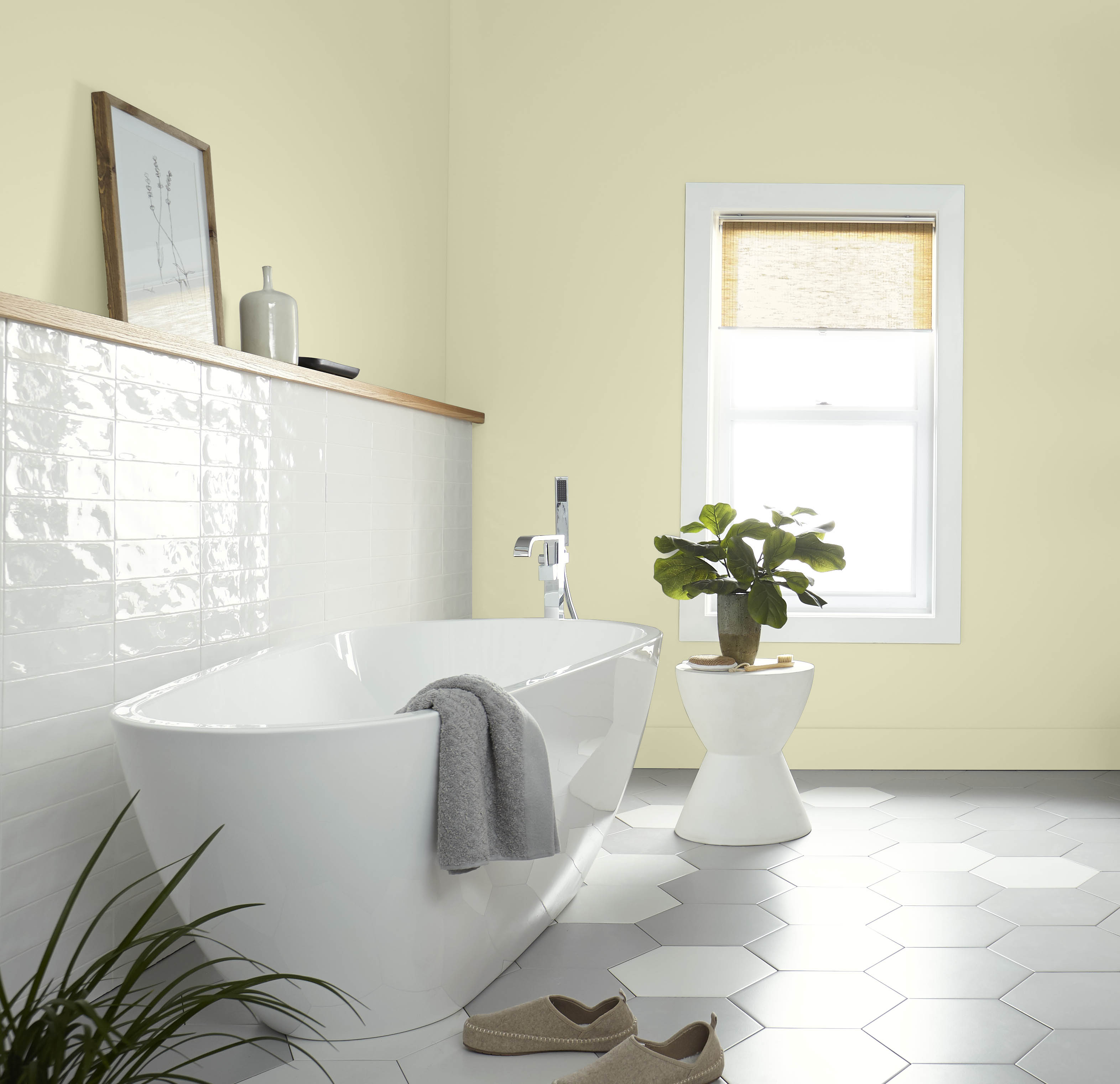 A bright bathroom with walls and baseboards in the colour Hybrid, with a bathtub and side table