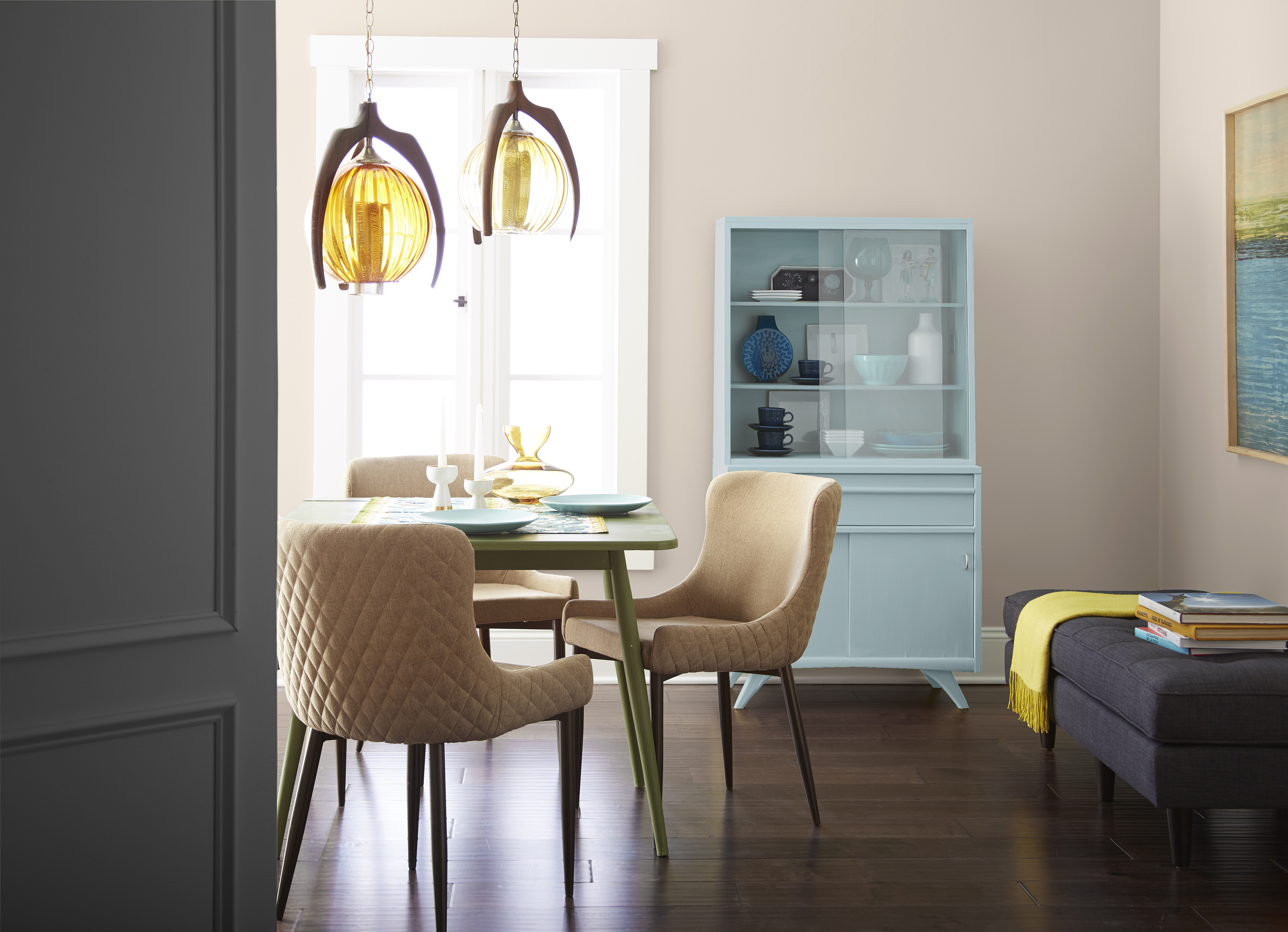 A bright dining room with walls in the colour Old Map and accent doors and furniture in Asphalt Gray and Clear Vista