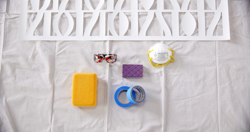 Tools for the project laid out on a white drop cloth