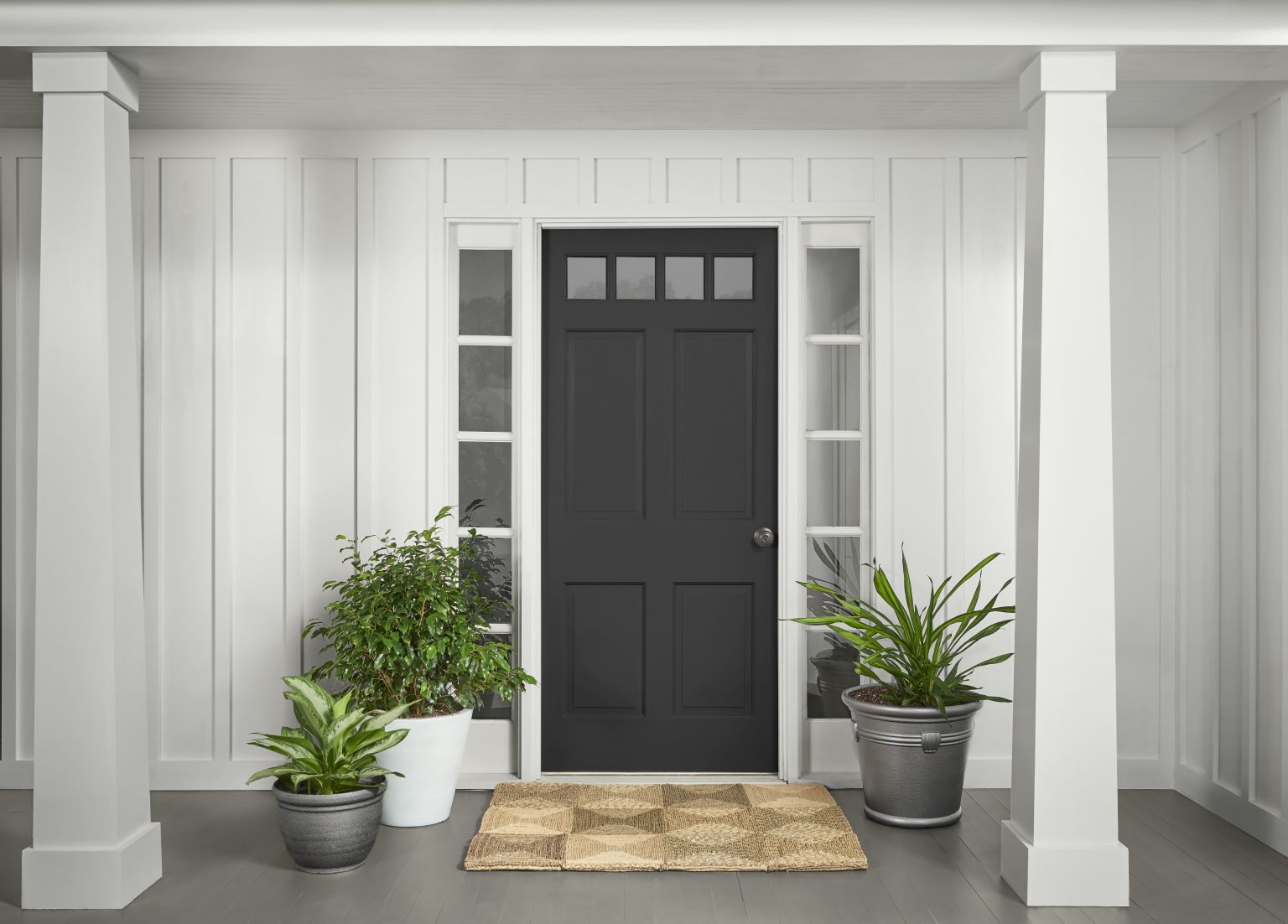 The exterior of a white house with the front door painted black